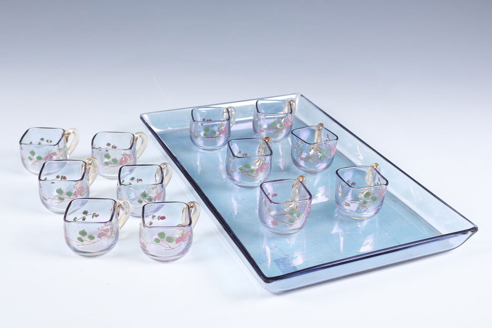 Liqueur service: Liqueur service Emile Gallé, Nancy, around 1880 - 1884 Consisting of a rectangular tray and twelve small cups. Colourless glass, flat blue-violet iridescent. The cups with all-round decoration in