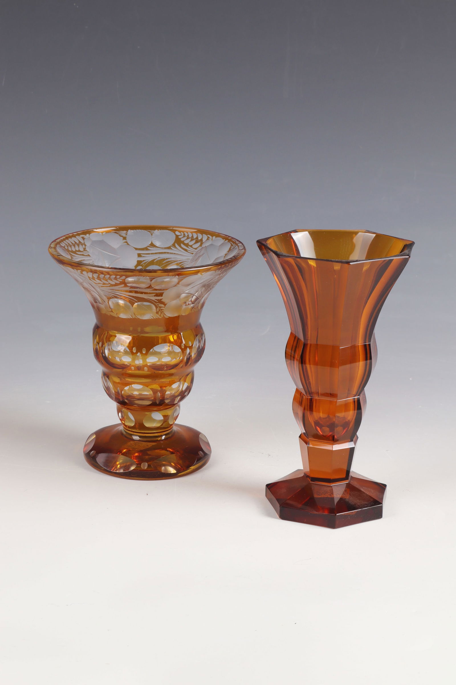 Mixed lot of two vases: Mixed lot of two vases Bohemia, A. 20th century, colourless, yellow-stained glass. One with cut floral décor and lens cut. The other faceted. H. 14 or 16 cm