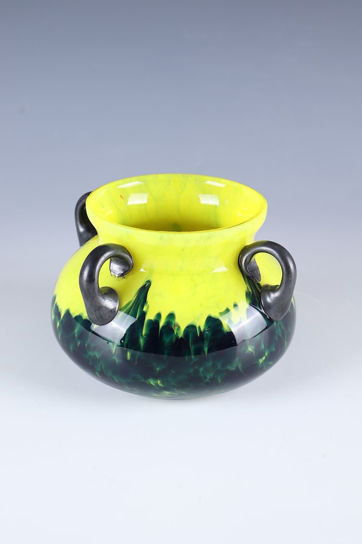 Decorative handle bowl: Ornamental handle bowl Bohemia, c. 1920 Colourless glass with melted crumbs in yellow and blue. Colorless overlay. Four appliquéd handles in violet. The handle iridescent. Bumped. H. 9.5 cm.