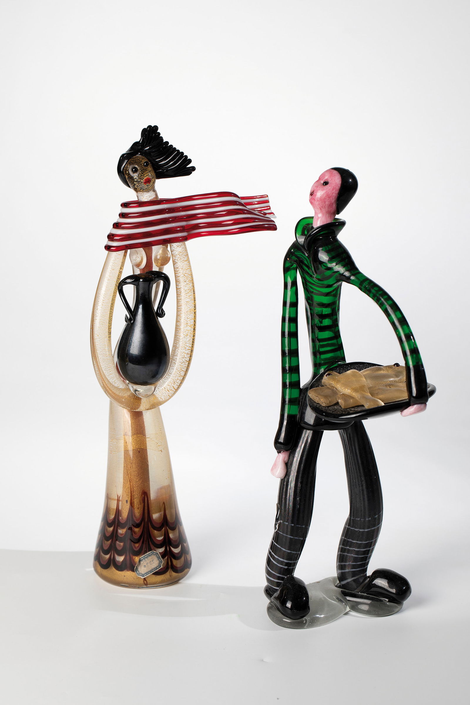 Pair of figures: Pair of figures Anzolo Fuga (design), Arte Vetreria Muranese (A.Ve.M.), Murano, 1956 Colourless, green, opaque white - partly with pink crumb melting - red and black glass. Freely formed and fused