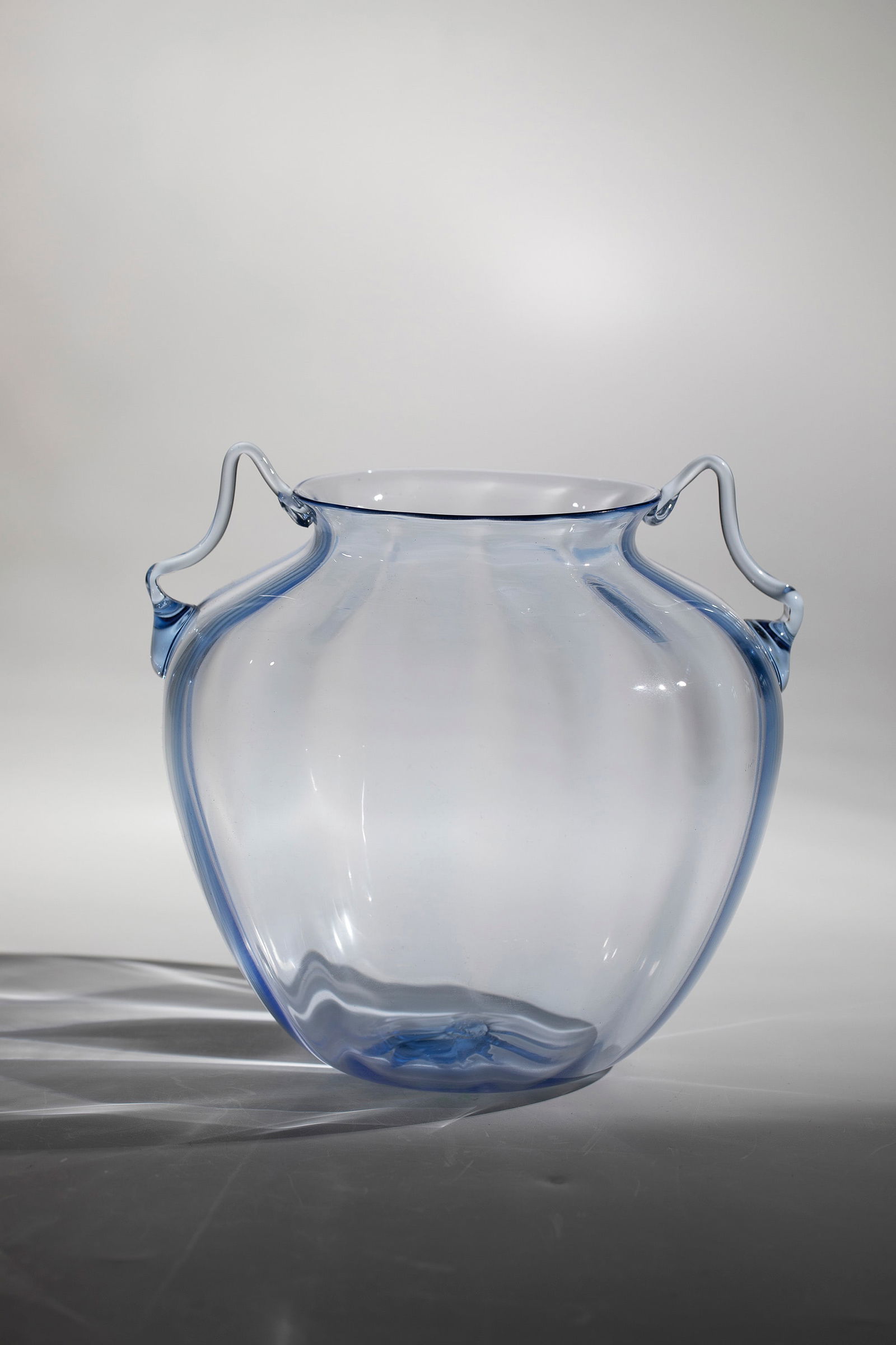 Handle vase ''Soffiato'': Handle vase ''Soffiato'' Vittorio Zecchin (design), Compagnia di Venezia e Murano - Pauly & C., c. 1920-30 Light blue, rib-optically blown glass. Freely attached, curved handles. H. 18 cm. Please note