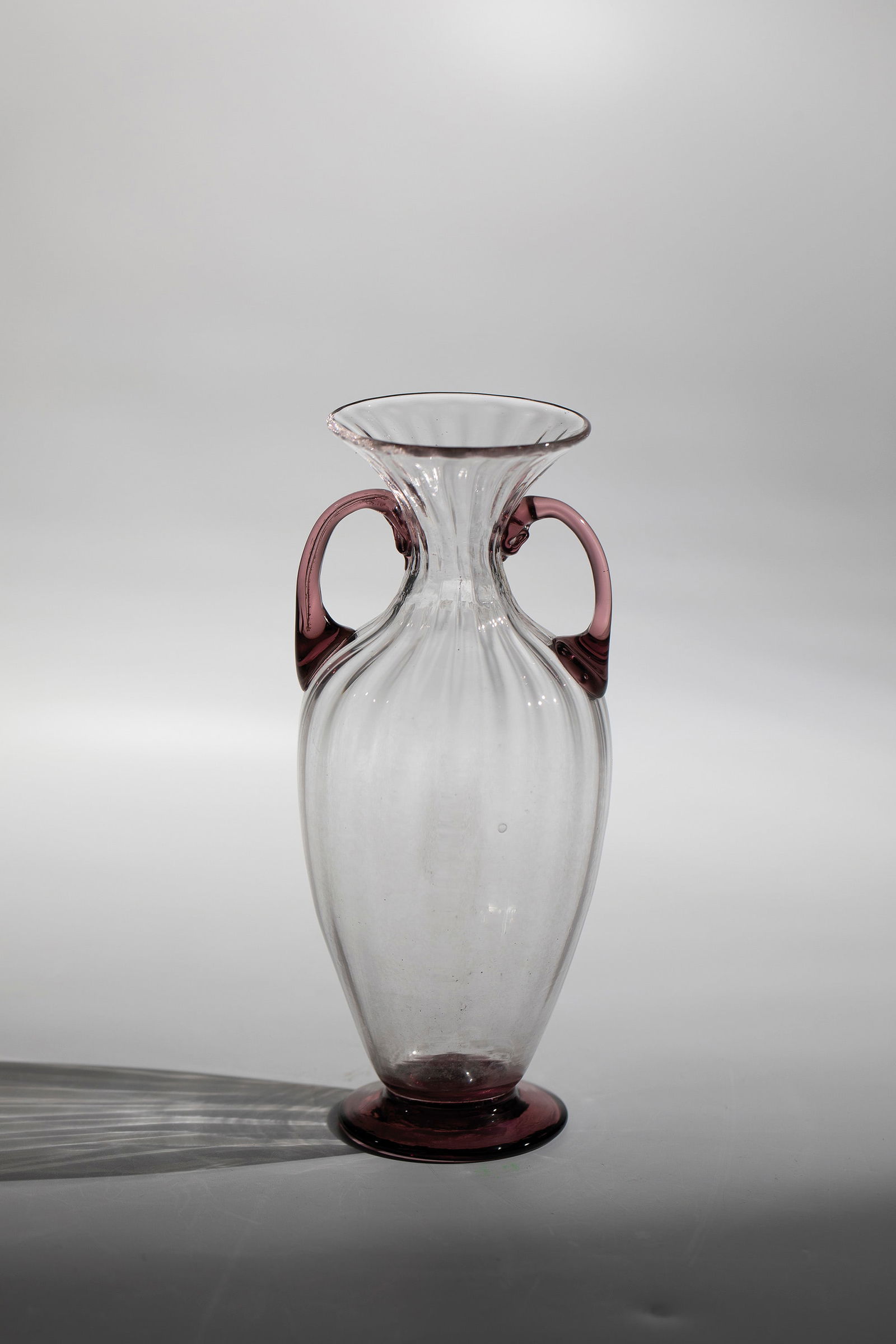 Small Handle Vase ''Soffiato'': Small Handle Vase ''Soffiato'' Compagnia di Venezia e Murano - Pauly & C., Murano, c. 1920-30 Colourless, rib-optically blown glass. The disc base and the freely attached handles in old pink. H. 15 cm