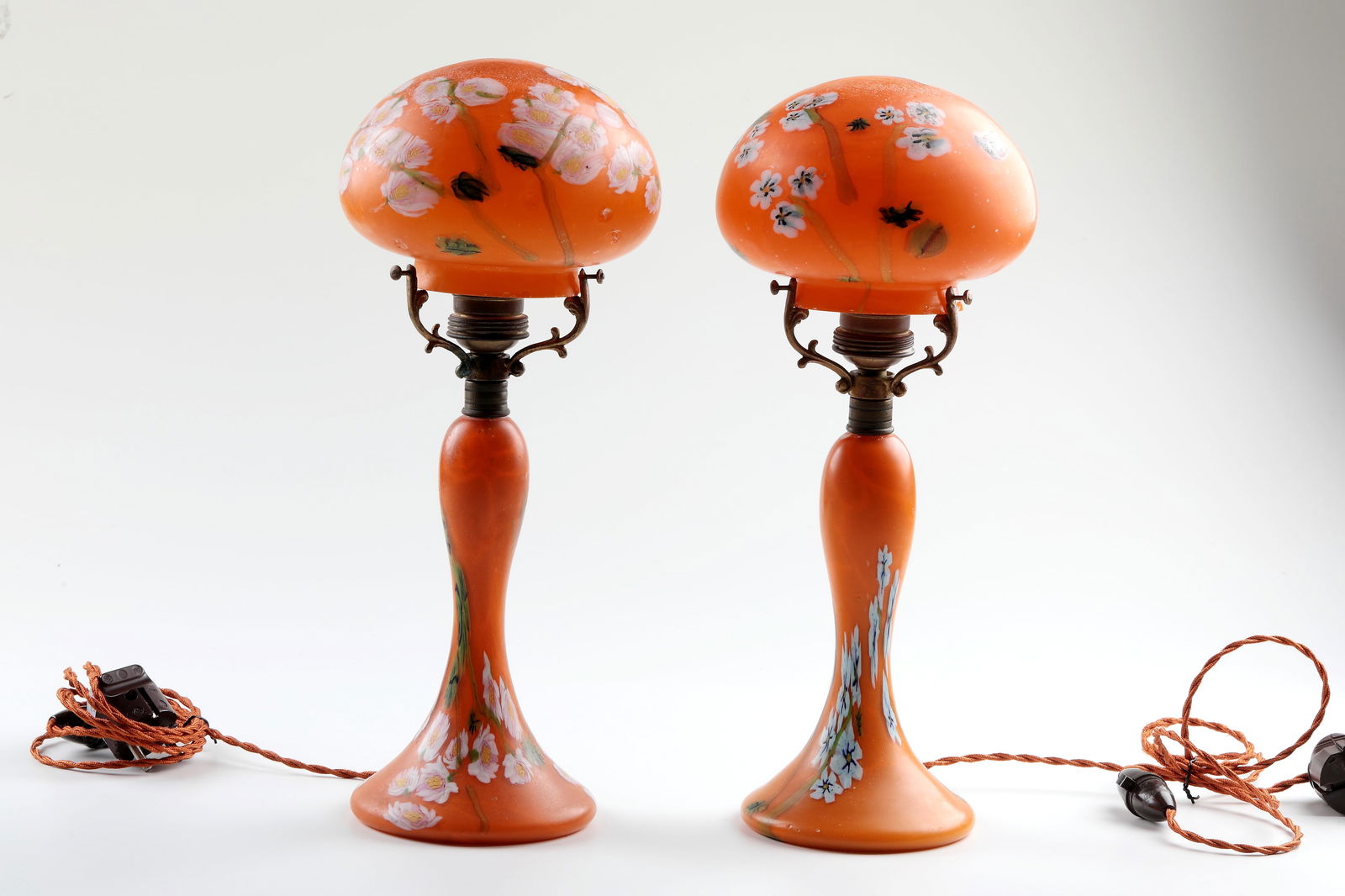 Pair of table lamps ''a murrine floreali policrome'': Two Table Lamps ''a murrine floreali policrome'' Fratelli Toso, Murano, circa 1910/20 Orange glass. Underlay in white opal, with melted multicolored murrine. Surface acid-matted. Electrification