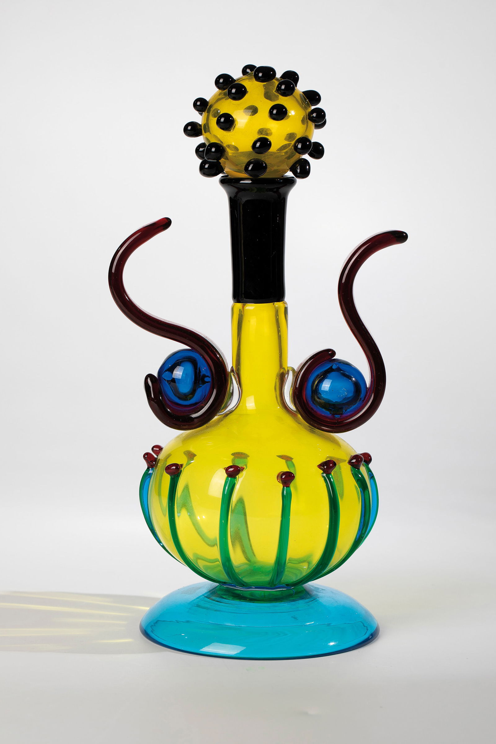 Bottle: Bottle Heinz Oestergaard (design), Salviati & C., Murano, 1993 coloured glass, melted together. Plug with black-violet, wall with green and ruby-red dot or thread melting. In Dimantriß described: