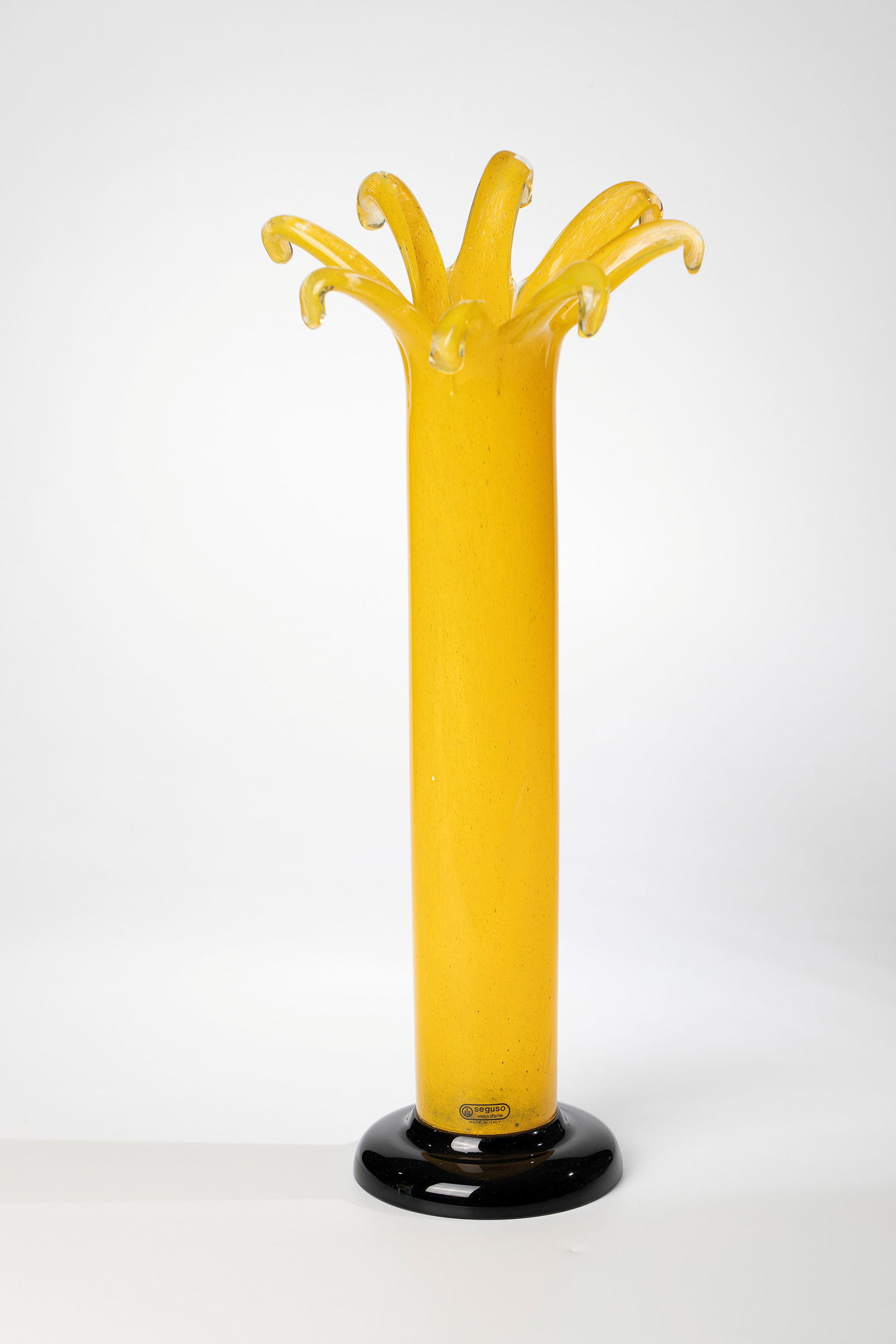 Tall Vase: Tall vase Seguso Vetri d'Arte, Murano, 1980-93 Colourless glass with opaque yellow crumb melting. Muzzle rim flower-shaped freely formed. The attached round stand made of black glass. Bottom