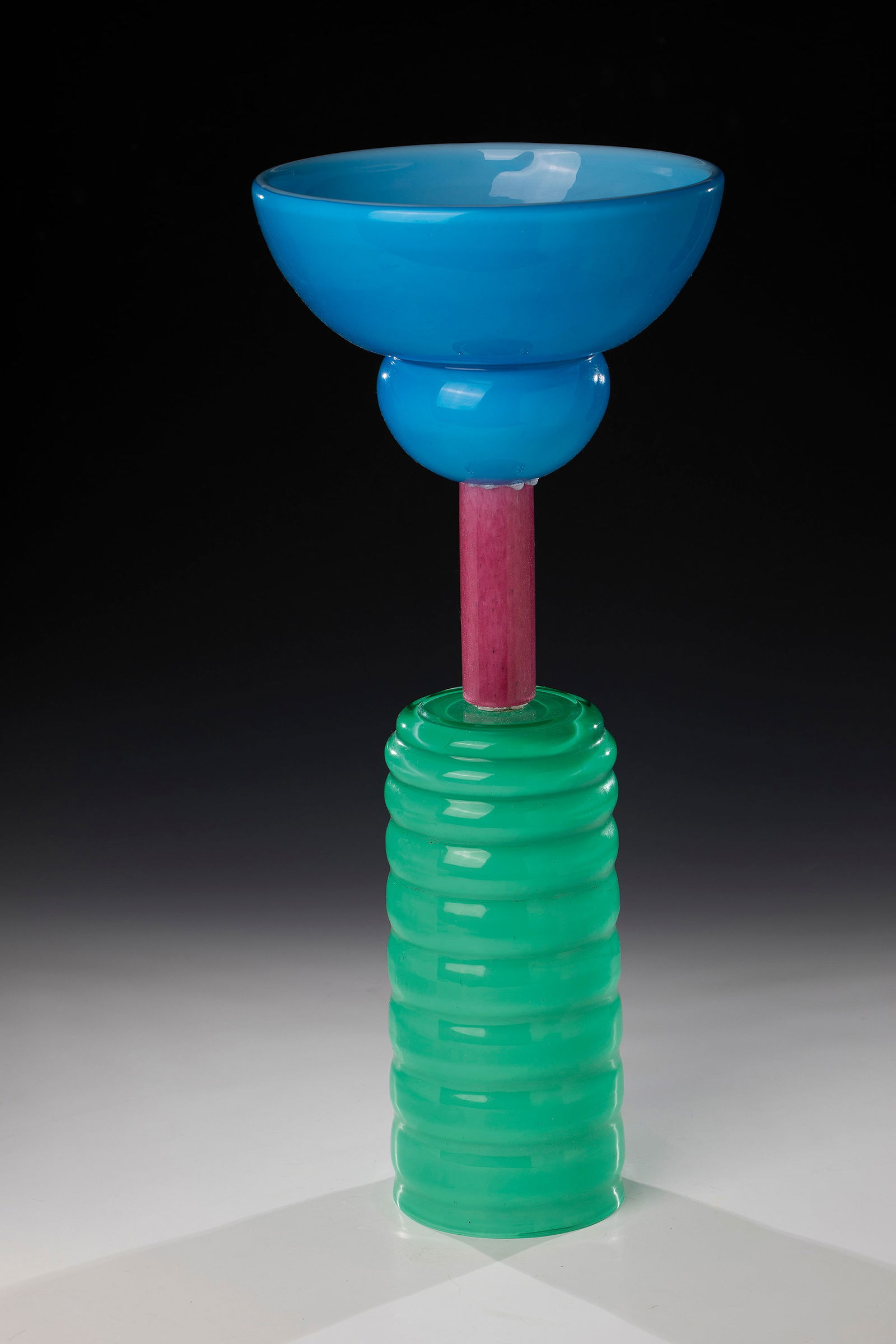 Object: Object Peter Shire (design), Vistosi, Murano, c. 1980 Colourless, partly rib-optically blown glass with blue, green, magenta and opaque white underlay. 2-part object composed of geometric shapes.