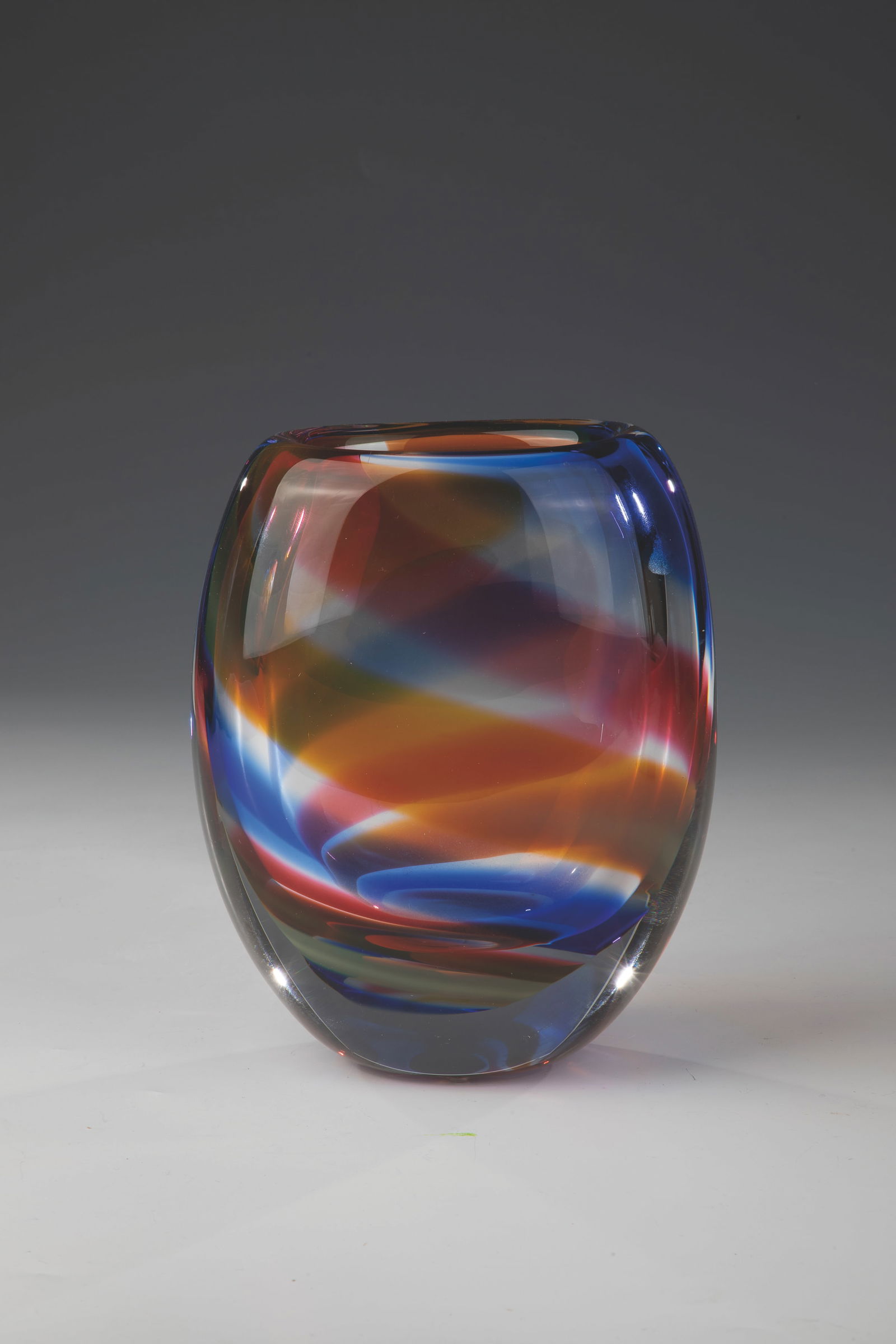 Vase: Vase Ulf Johansson, Sjöhyttan, c. 1989 Thick-walled, colourless glass with diagonal, melted colour bands in blue, orange and violet. Engraved underside: Sjöhyttan Ulf Johansson. H. 17.5 cm.