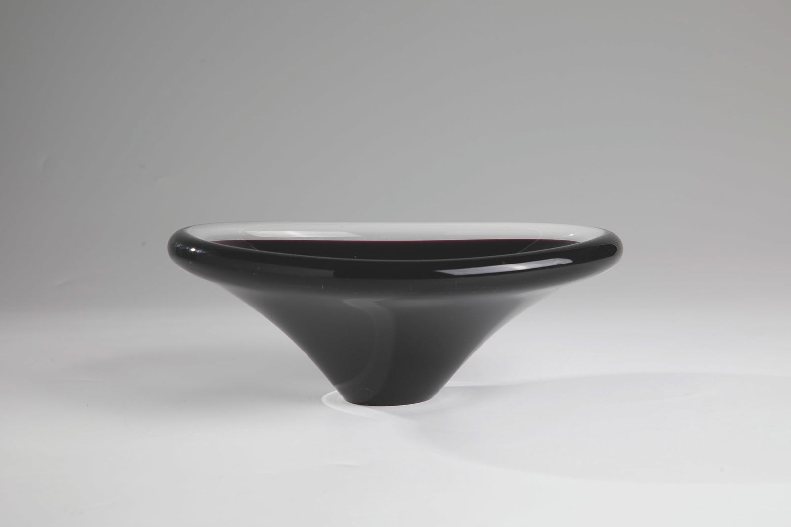 Shell: Bowl Scandinavia, c. 1950/60 thick-walled, colourless glass. Red-violet underpinning. Remnants of a manufacturer's label. H. 8 cm; L. 21.5 cm.