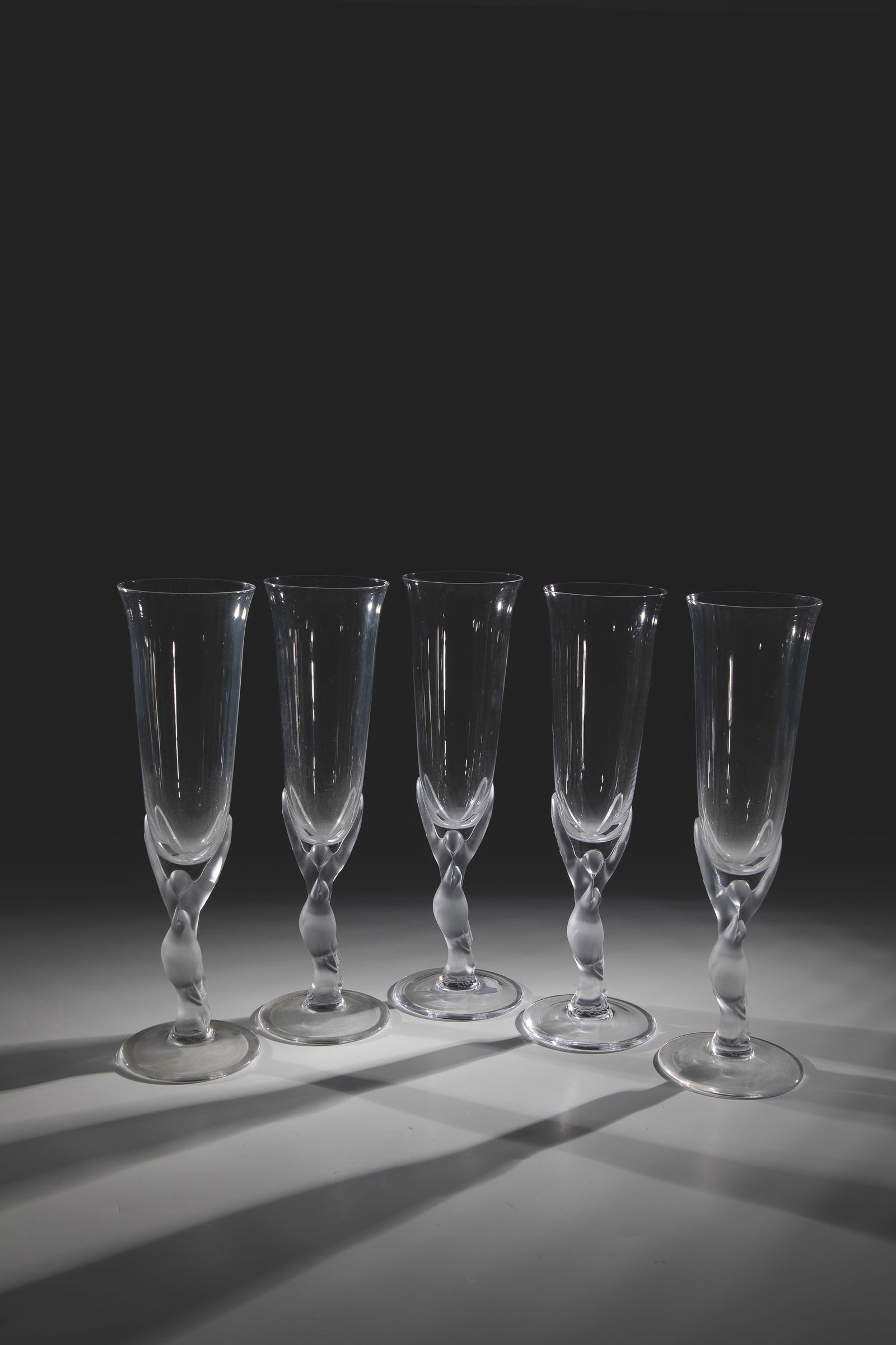 Five Flutes ''The Snow Dove'': Five Flutes ''The Snow Dove'' Fabergé, France, 1980s Colorless glass, pressed into the mold, satin shaft in the shape of two stylized doves. Each with etching stamp. H. 24.5 cm.