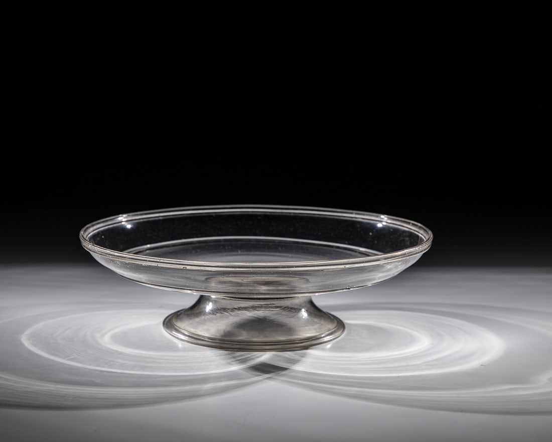 Foot shell: Foot bowl Venice or Facon de Venise, 16th century Grey-tinted glass. Flared foot with tear-off and folded edge downwards. Flat shell base with diagonally ascending, rounded wall. In the middle of the 