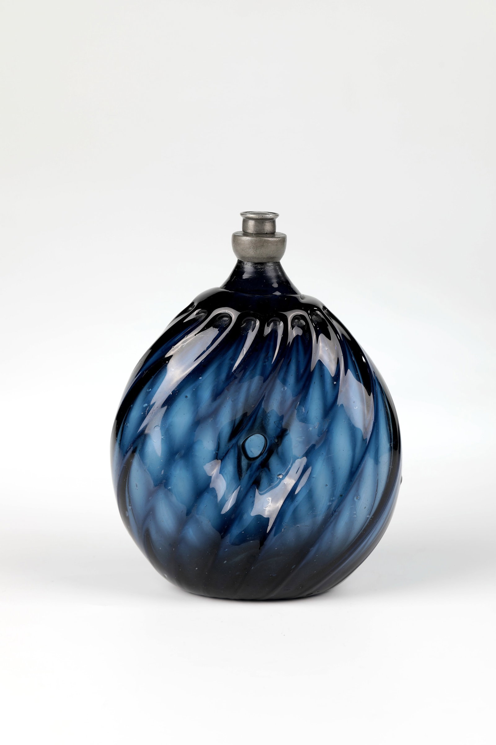 Rare umbilical bottle: Rare umbilical bottle, Alpine 18th century, cobalt blue glass with tear-off. Bulbous, flattened on both sides, diagonally ribbed wall with navel-shaped groove. Tin screw cap. H. 17 cm Cf. Lit. :