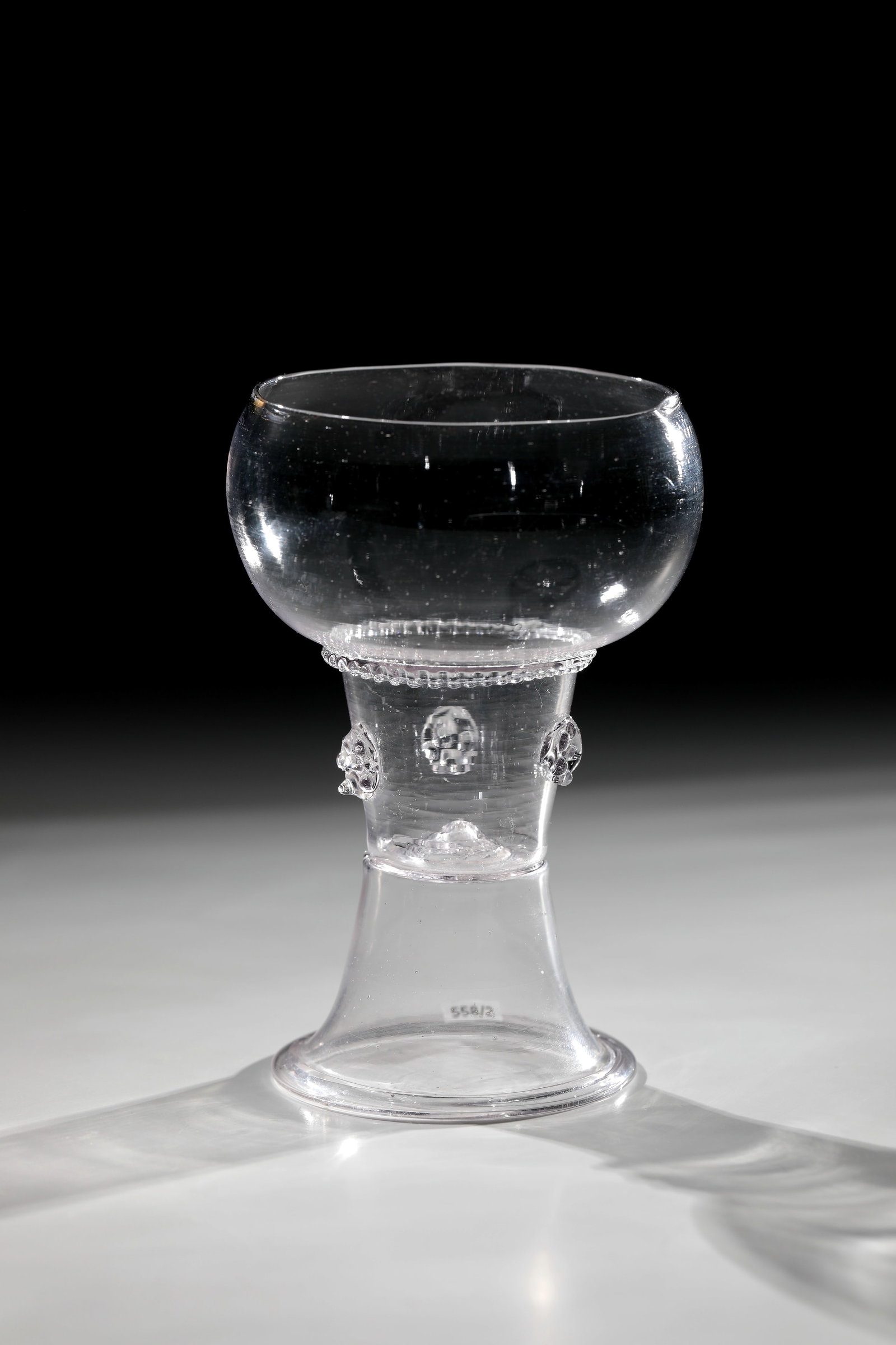 Romans: Roman North German, 18th century Colourless, thin-walled glass with demolition. Trumpet foot with inward-folded edge. Shaft open at the top with three appliquéd berry nubs. Below the bulbous cuppa, a