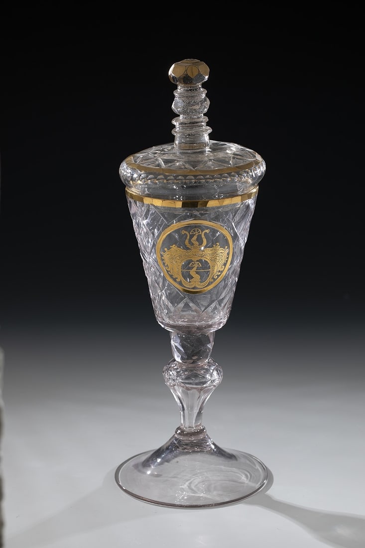 Lidded goblet with coat of arms: Lidded goblet with coat of arms. Central Germany, mid-18th century. Manganese-like glass with tear-off and raised disc base. Hollow baluster shaft with pronounced nodus. The shaft, cuppa, top of the