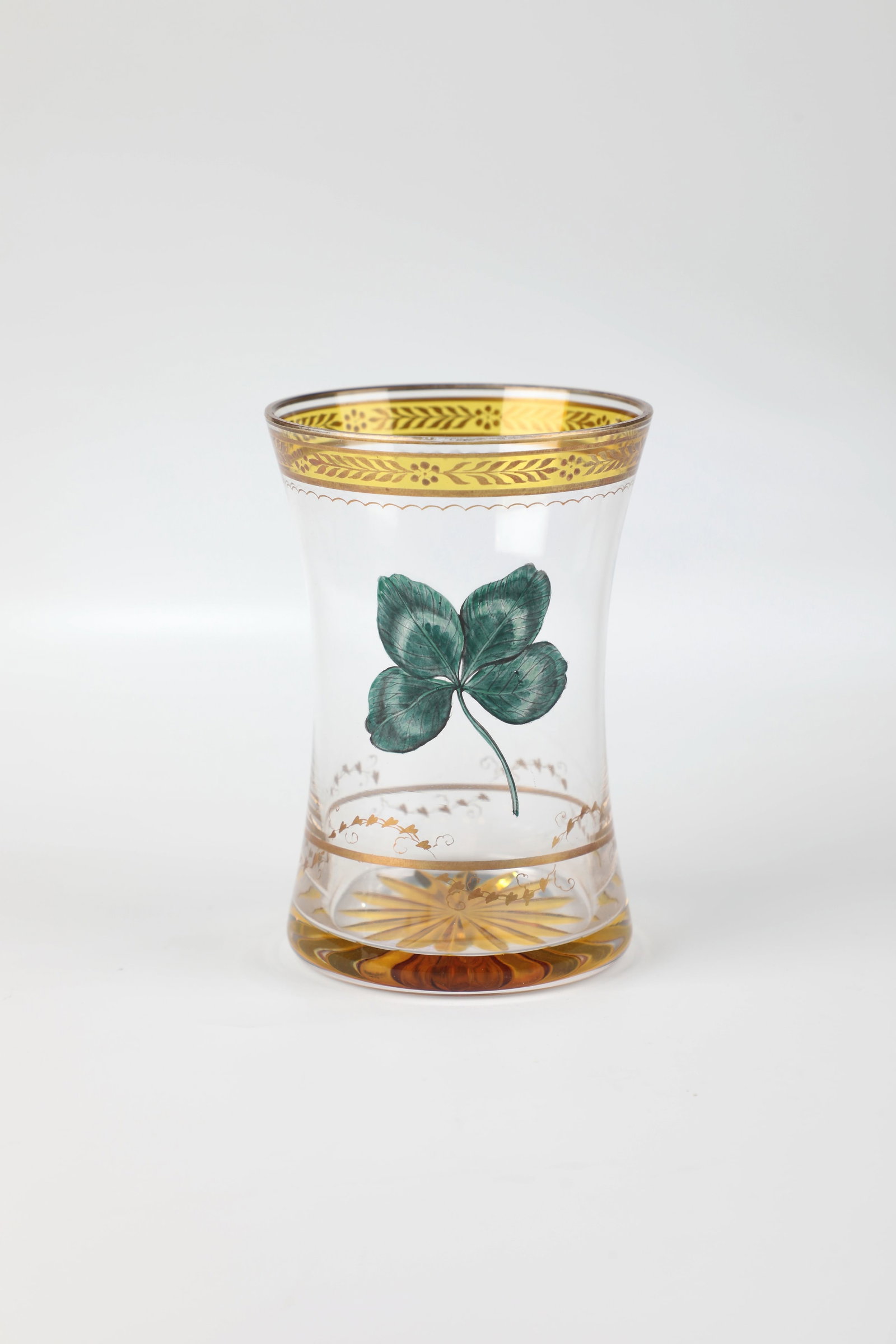 Mug with four-leaf clover: Beaker with four-leaf clover Anton Kothgasser, Vienna c. 1820 Colourless glass with a yellow-stained notched star incorporated into the bottom. Frontal on the waisted wall in transparent enamel and bl
