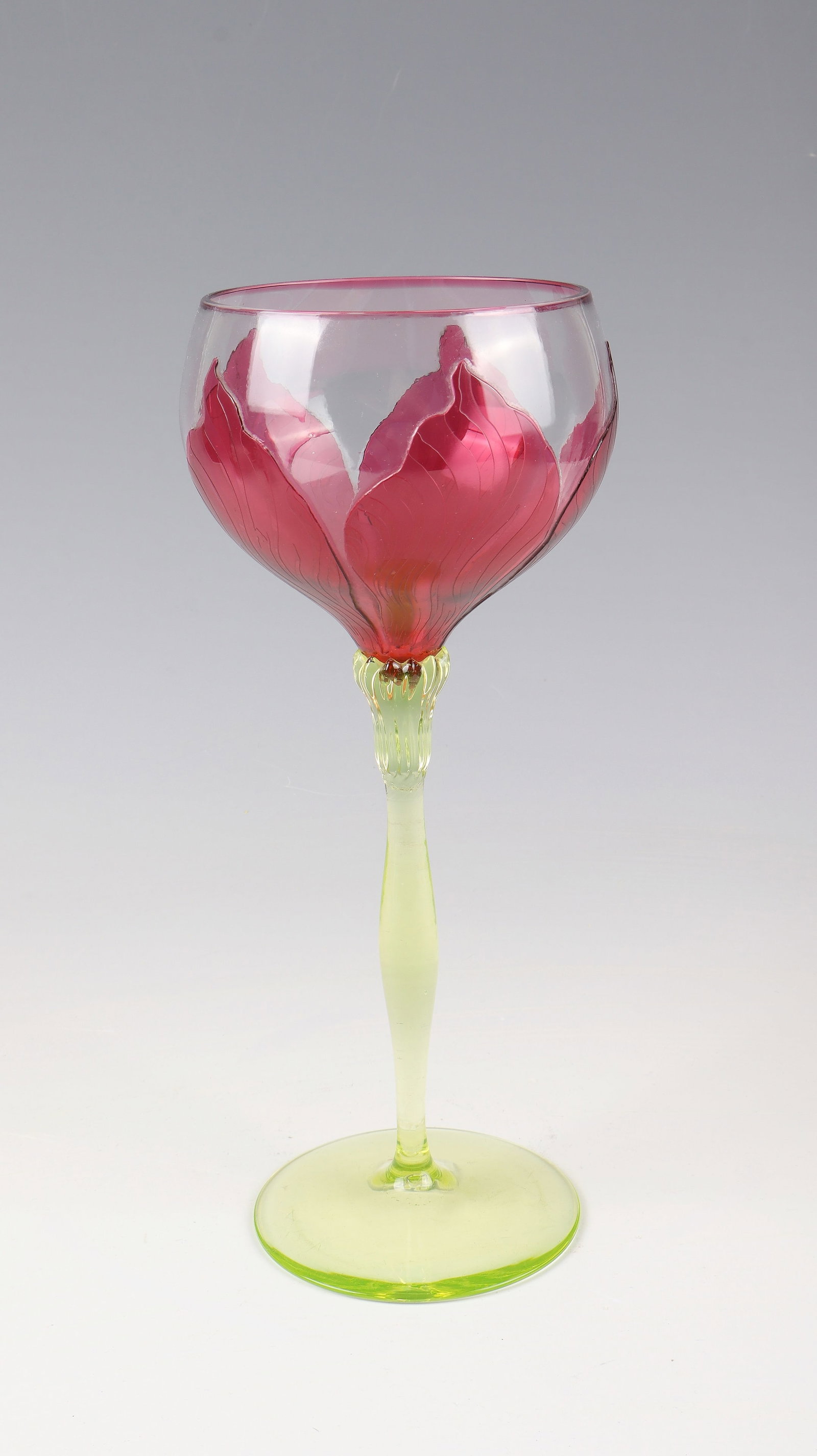 Wine glass: Wine glass Rheinische Glashütten AG, Cologne-Ehrenfeld, c. 1900 feet and shaft made of light green uranium glass. Kuppa made of colourless, ruby-pink overlaid glass. Relief etched decoration of styli