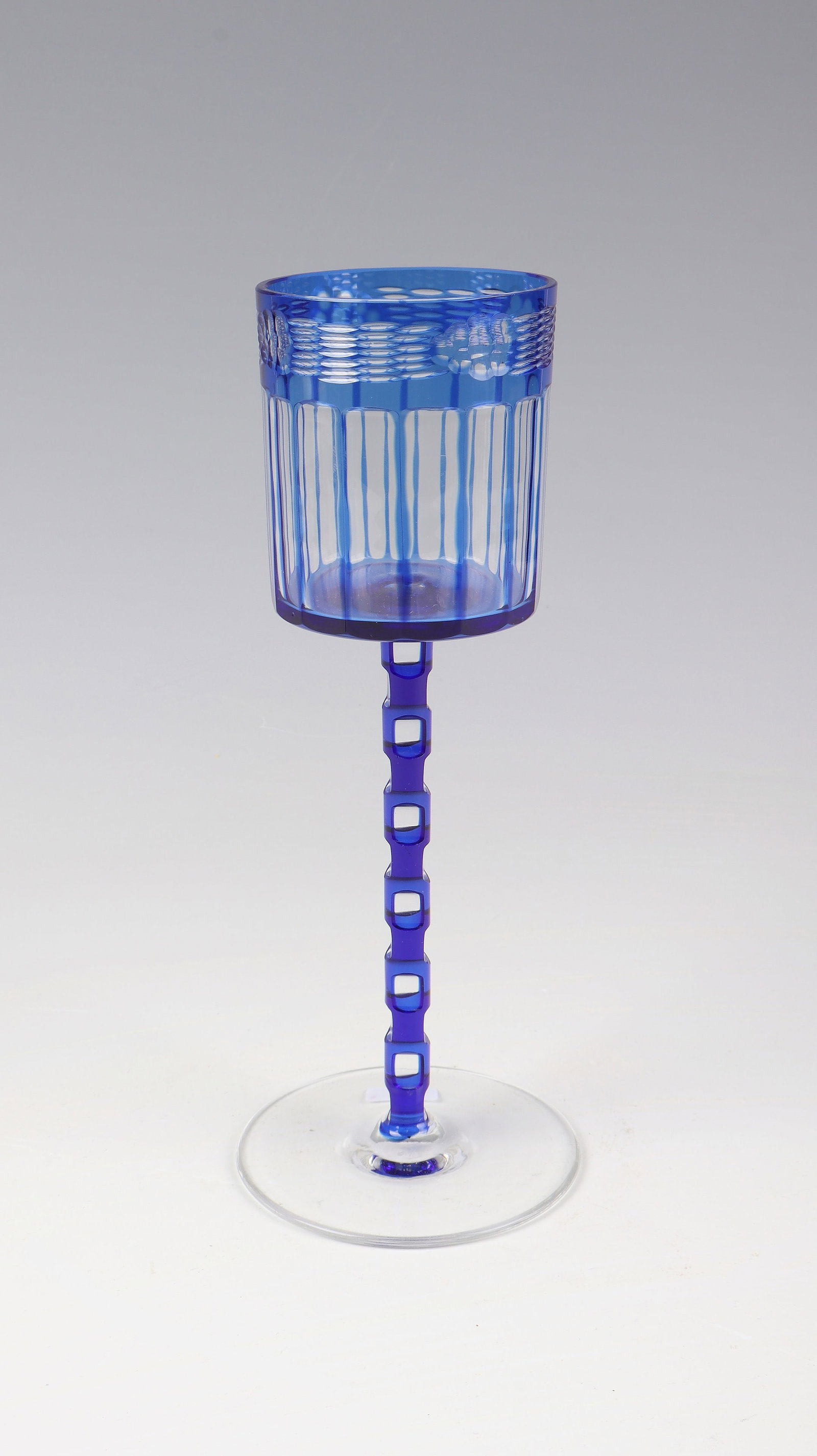 Wine glass: Otto Prutscher wine glass (design), Meyr's nephew, Adolf bei Winterberg, c. 1910 Colourless, cobalt blue overlaid glass. Cylindrical cuppa with sixteen-fold peel grind. Below the lip are four carved
