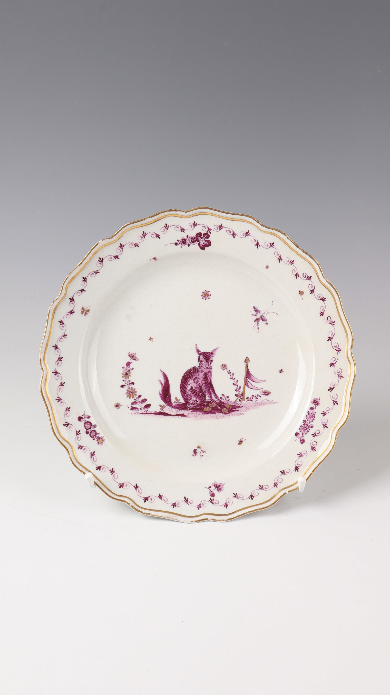 Plate with mythical creature: Plate with mythical creature Meissen around 1740 Porcelain, decorated in purple camaieu and gold: in the centre of the mirror a bizarre animal on a landscape island, surrounded by scattered flowers