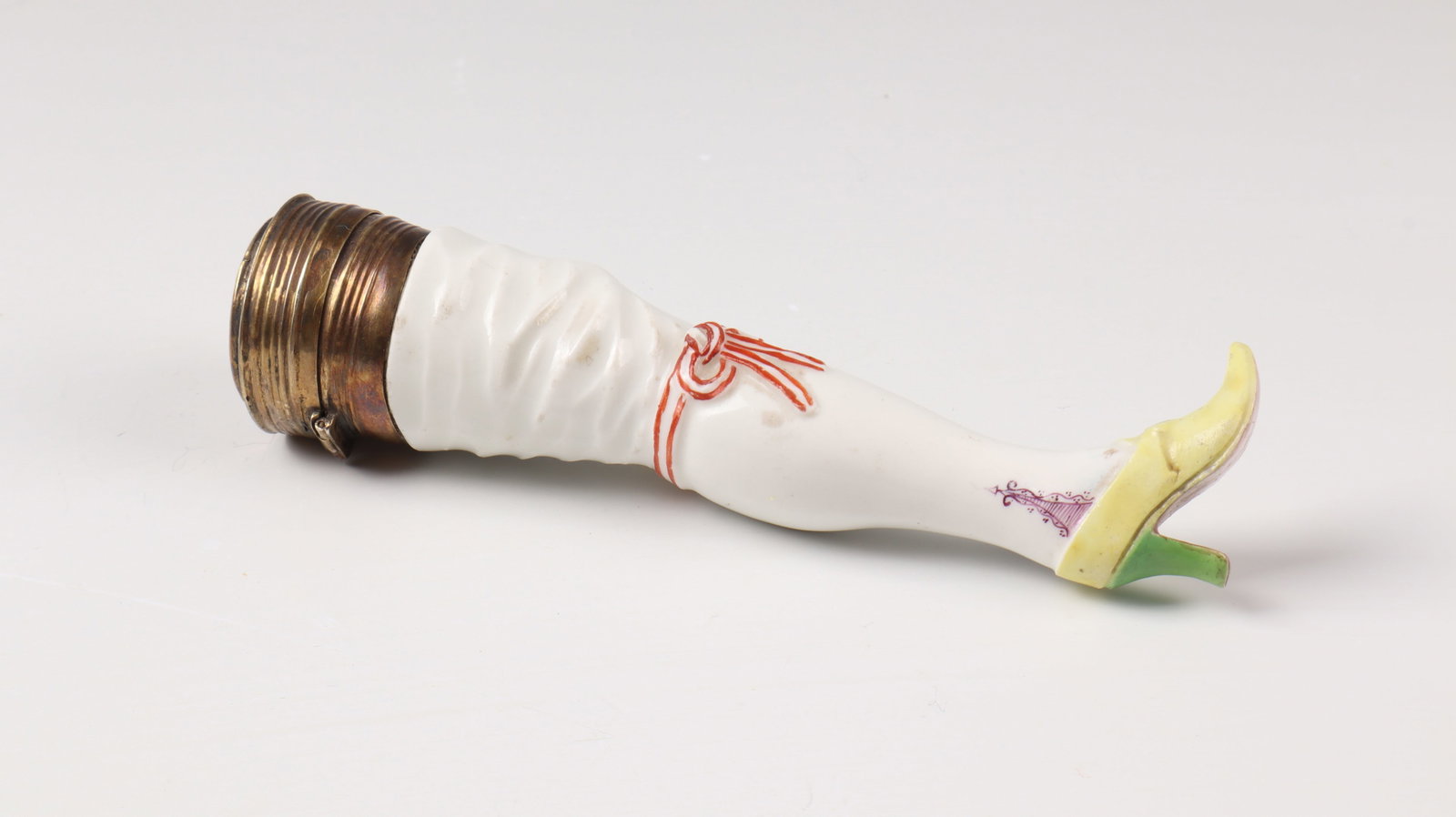Rare case as a pipe stopper (''flea leg''): Rare case as a pipe stopper (''flea leg'') Meissen around 1740, after a model by J.F.Eberlein Pipe stopper as leg with stocking, polychrome painted, relief bow and stocking, as box with gilded mount a