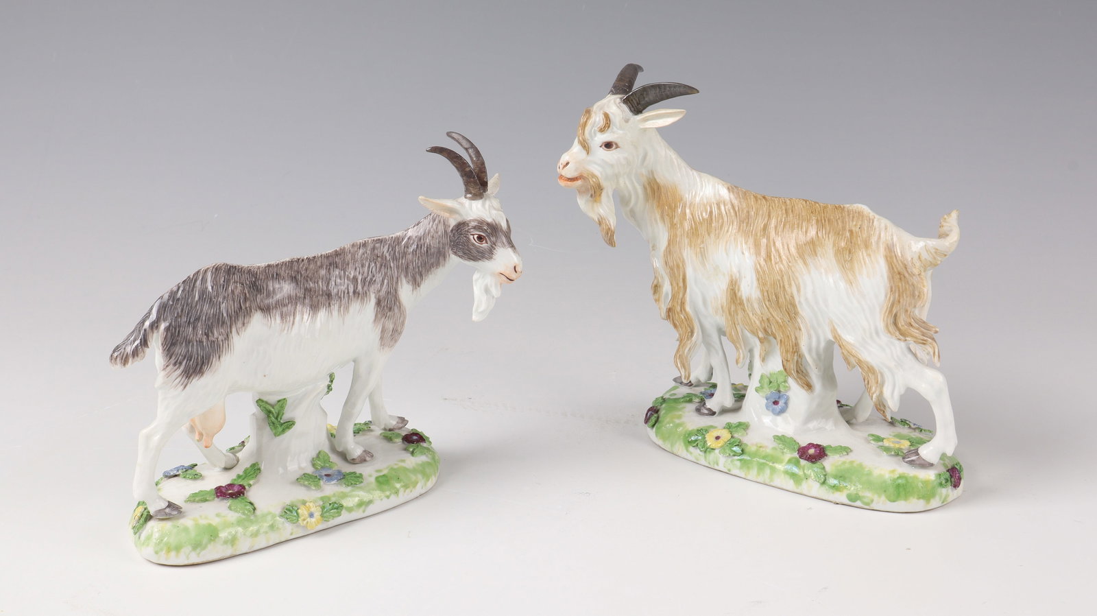 Pair of a goat and a billy goat: Pair of a goat and a billy goat Meissen, c. 1760/65 - after a model by J.J. Kändler Porzellan. Colour staffage. Standing on grass pedestal. Blue sword mark. Restored. H. 13.5 and 15 cm. Cf.