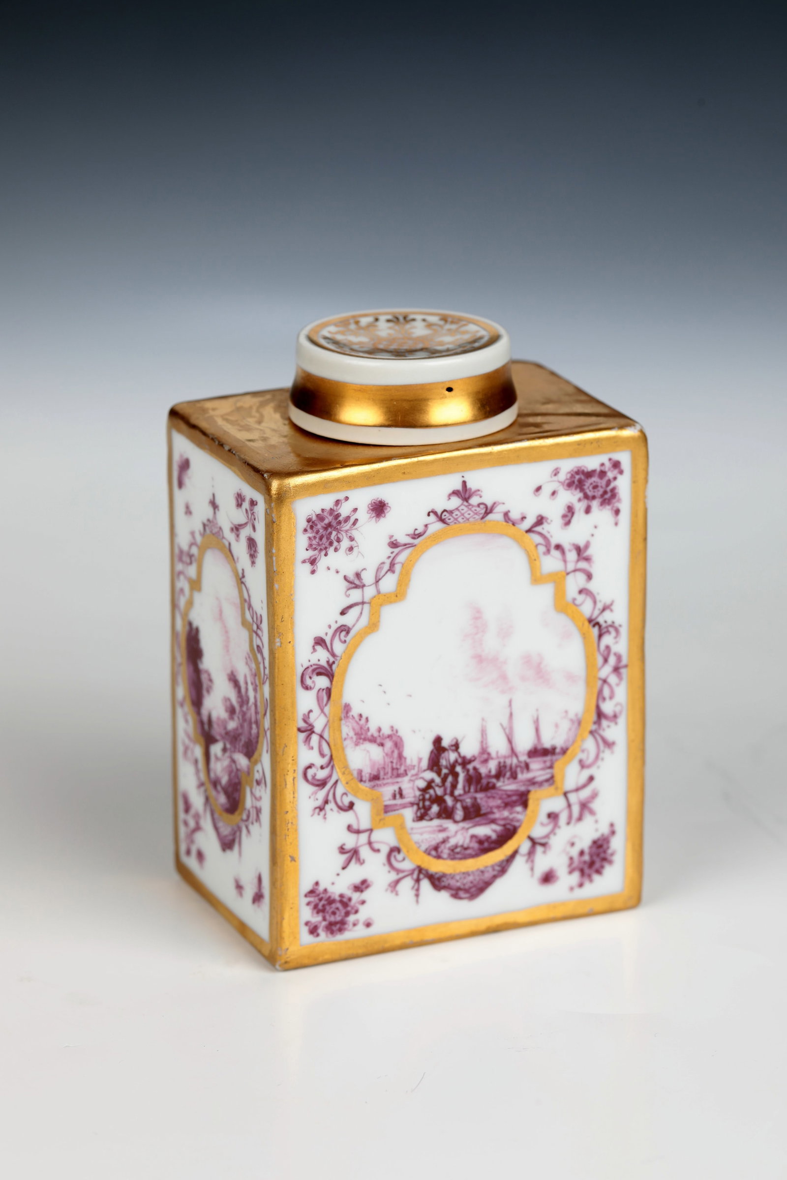 Tea caddy: Tea caddy Meissen around 1730 Cubic body with short muzzle and slip-on lid. Scenes finely painted in purple camaieu in gold-framed cartouches with foliage and bandwork: resting shepherd couple with an