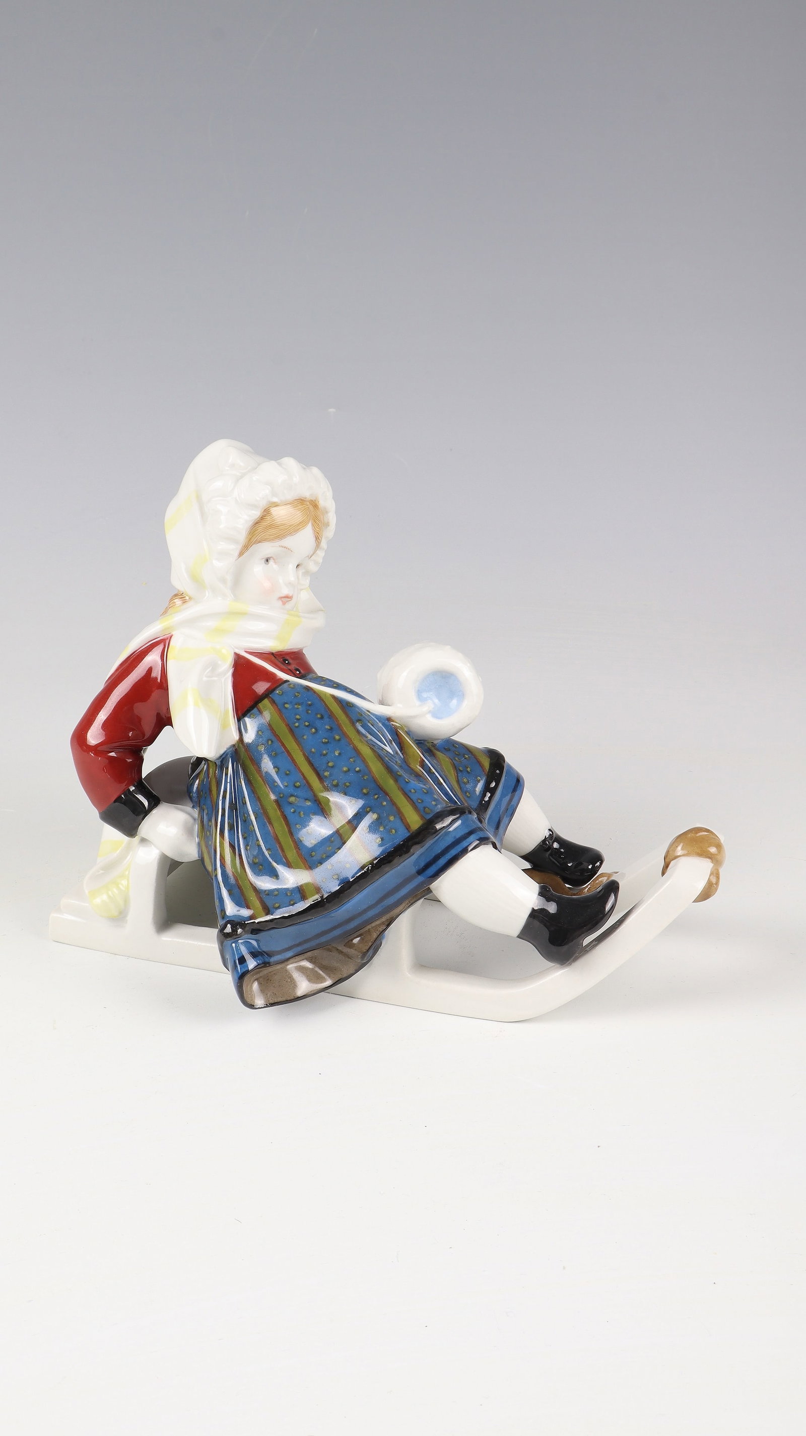 Girl on sled ''Clear the way'': Girl on a sleigh "Clear the way" KPM Berlin, designed by Martin Fritzsche 1910 Porcelain, polychrome painted, glazed. Girl sitting bent back on a sleigh in typical winter clothes and a muff slung