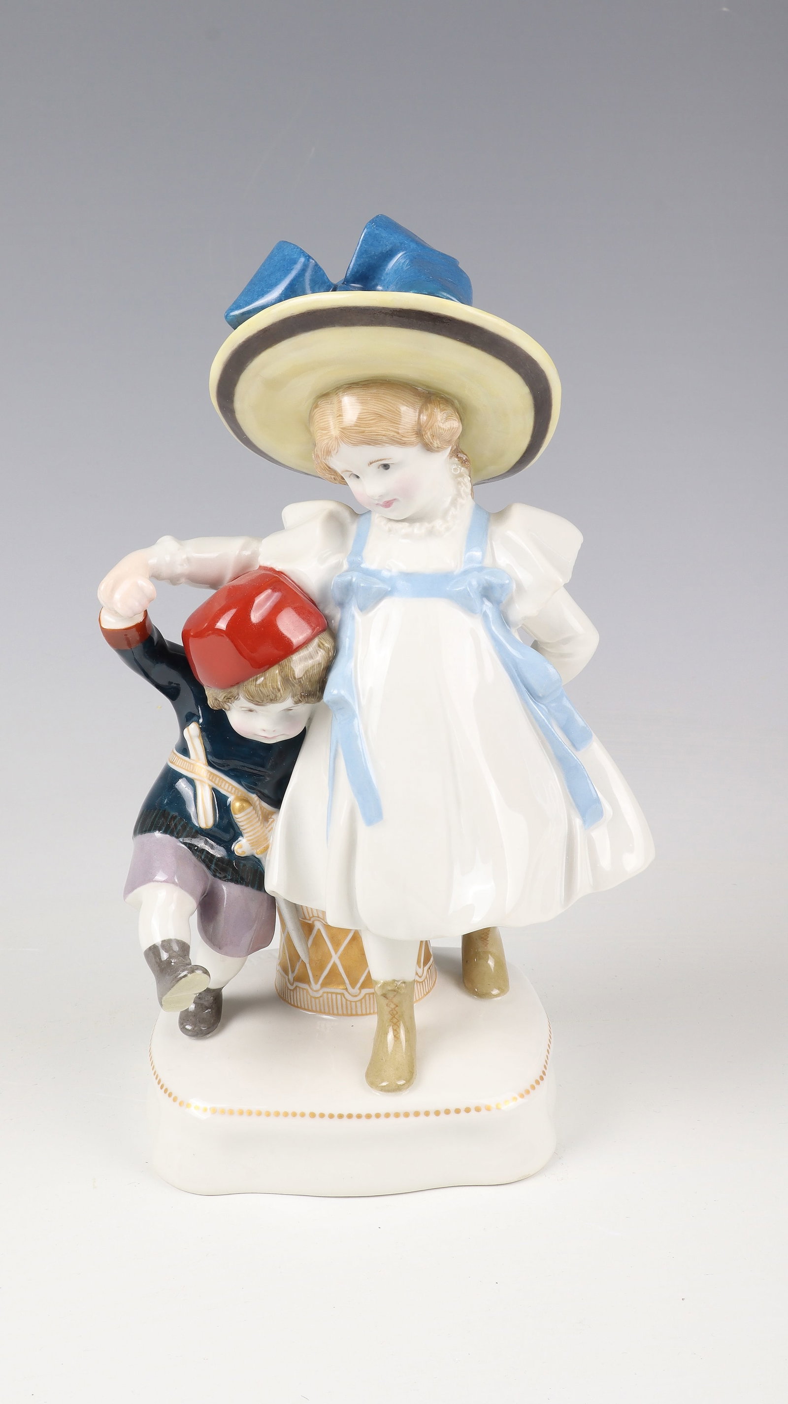 Group of figures ''Dear Fatherland can be quiet'': Figural group "Dear Fatherland Can Be Quiet" KPM Berlin, designed by Martin Fritzsche 1910 porcelain, with polychrome painting and gold staffage. Pair of siblings with drum on cushion-shaped base.