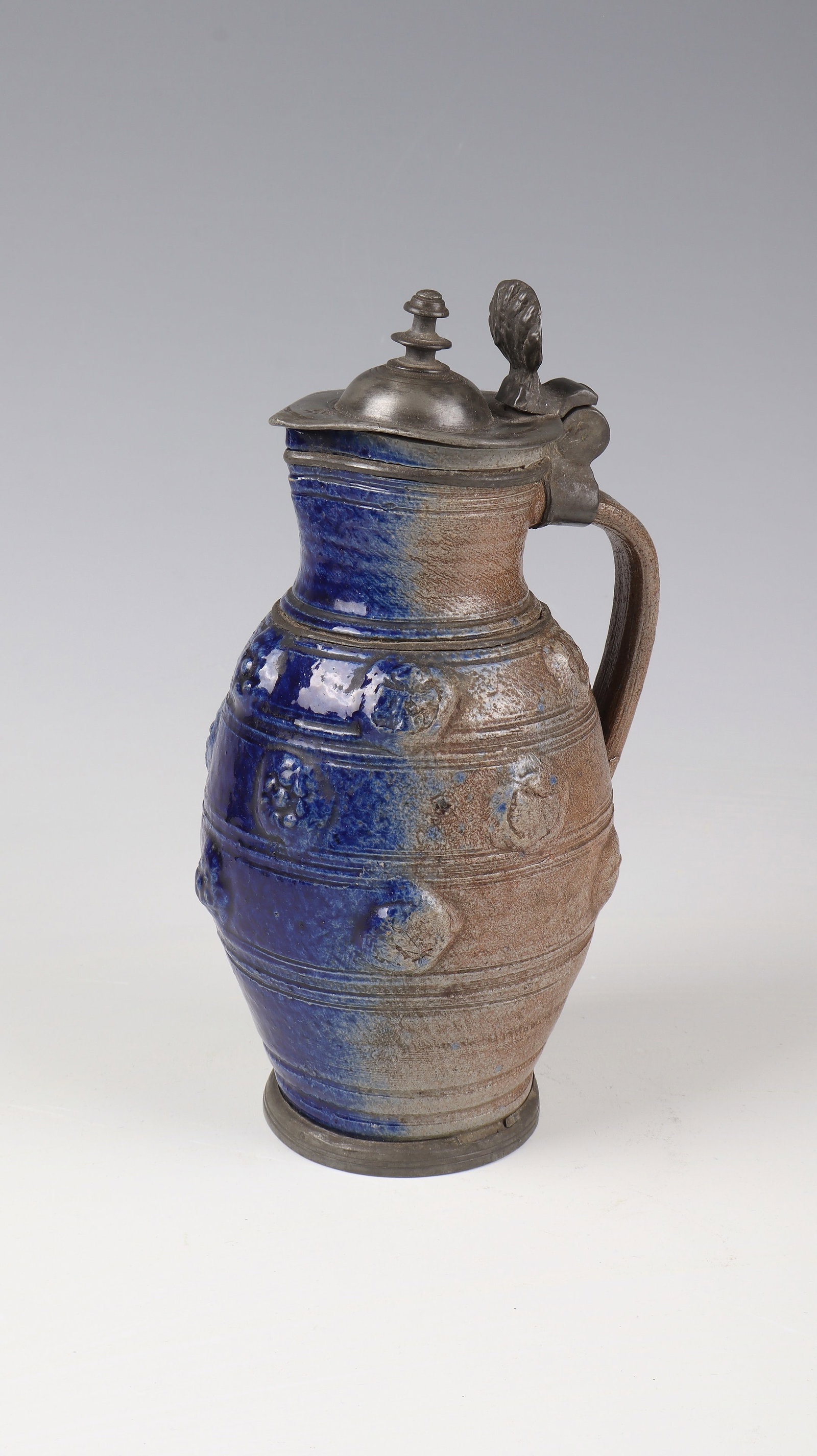 Mussel pot with blue apron and pewter mount: Museum pot with blue apron and pewter mount Zeitz, c. 1630 Pewter standing ring, slender, bulging wall made of grey-brown stoneware with regularly arranged transverse grooves, interspersed with relief