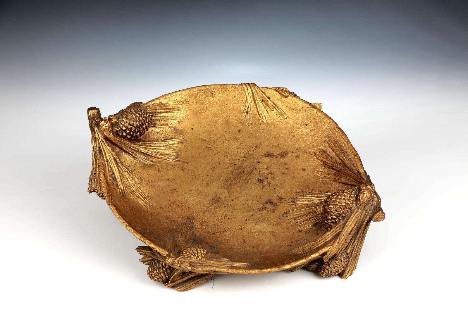 Bronze bowl with pine cones: Bronze Bowl with Pine Cones Demétre H. Chiparus | Demeter Chiparus (1886-1947) and Joseph Gazan (1891-1985), 1920 - 1930 bronze, cast and gilded. In cross-section, oval bowl on four plastic pine