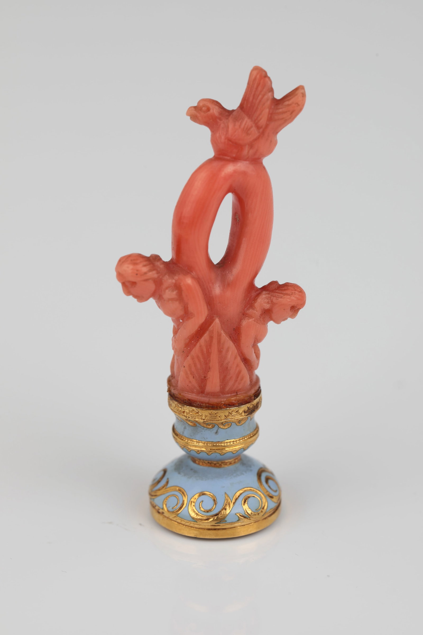 Miniature Seal: Miniature seal German, 18th/19th century Figuratively carved shaft on coral with two female figures and a bird. Gold-decorated porcelain base. On the underside, low-cut coat of arms in gold setting. H