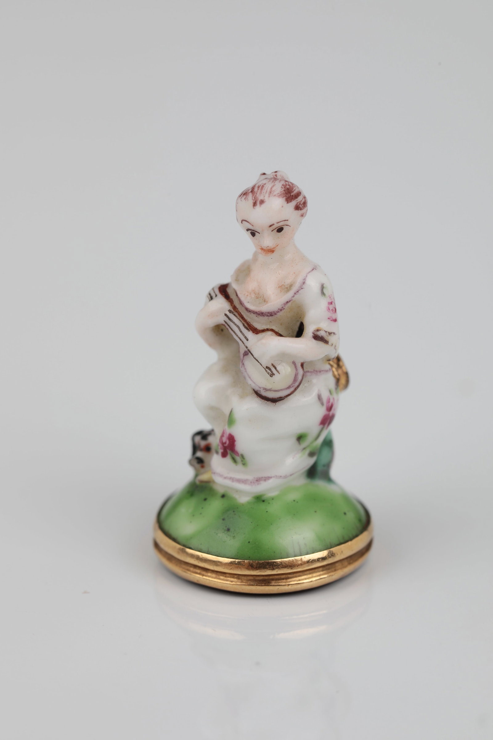 Miniature Seal: Miniature Seal German, 18th/19th Century Worked as a trailer. Shaft made of porcelain, in the form of a seated lady playing the mandolin, at her feet a dog. Rear hitch. Seal in gold-set carnelian with