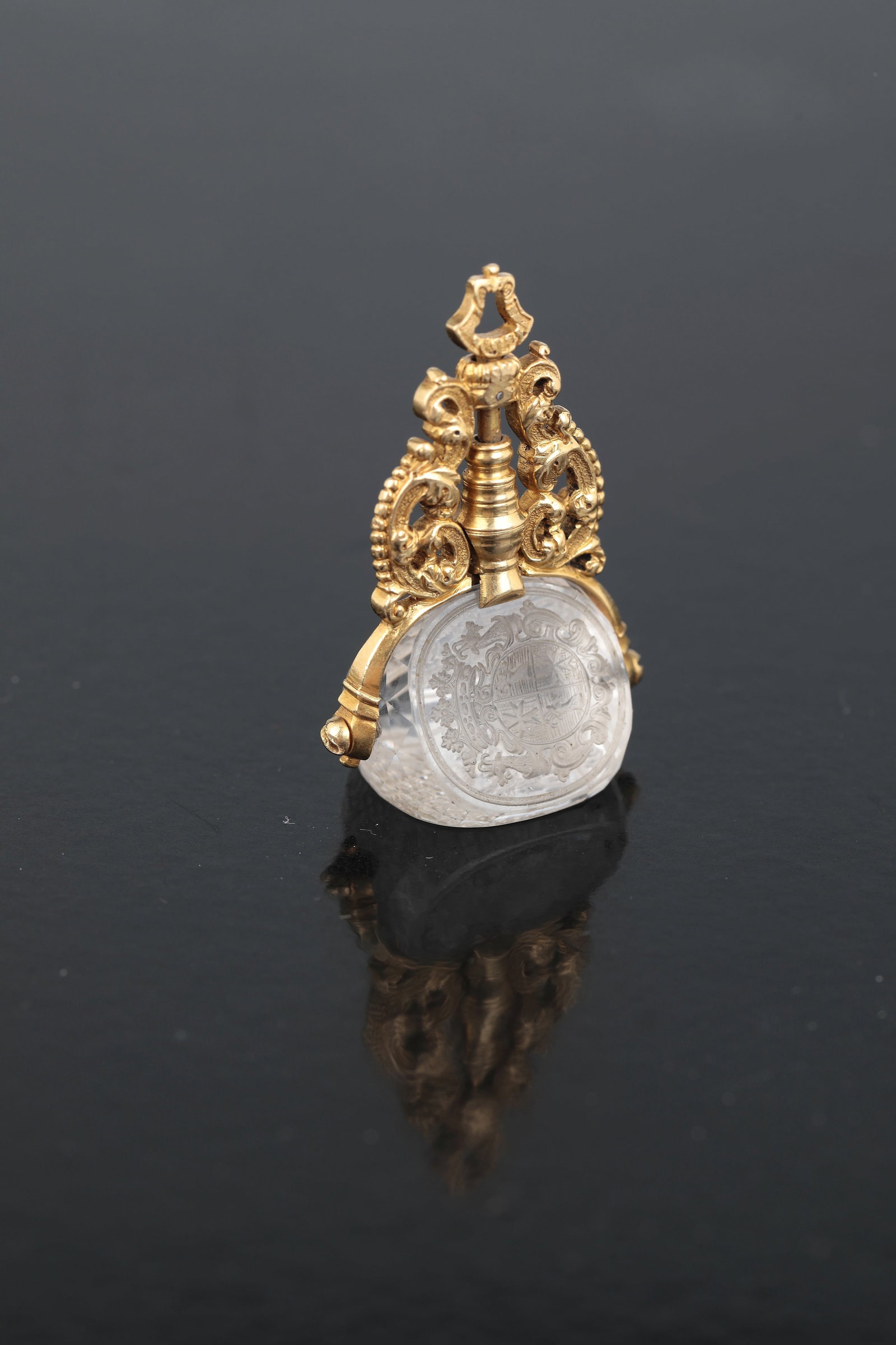 Rare seal as pendant: Rare seal as pendant German, 18th century, holder made of gold with finely worked baroque ornaments. Three-sided, prism-like cut seal made of rock crystal, the three sides with a very fine deep cut: c