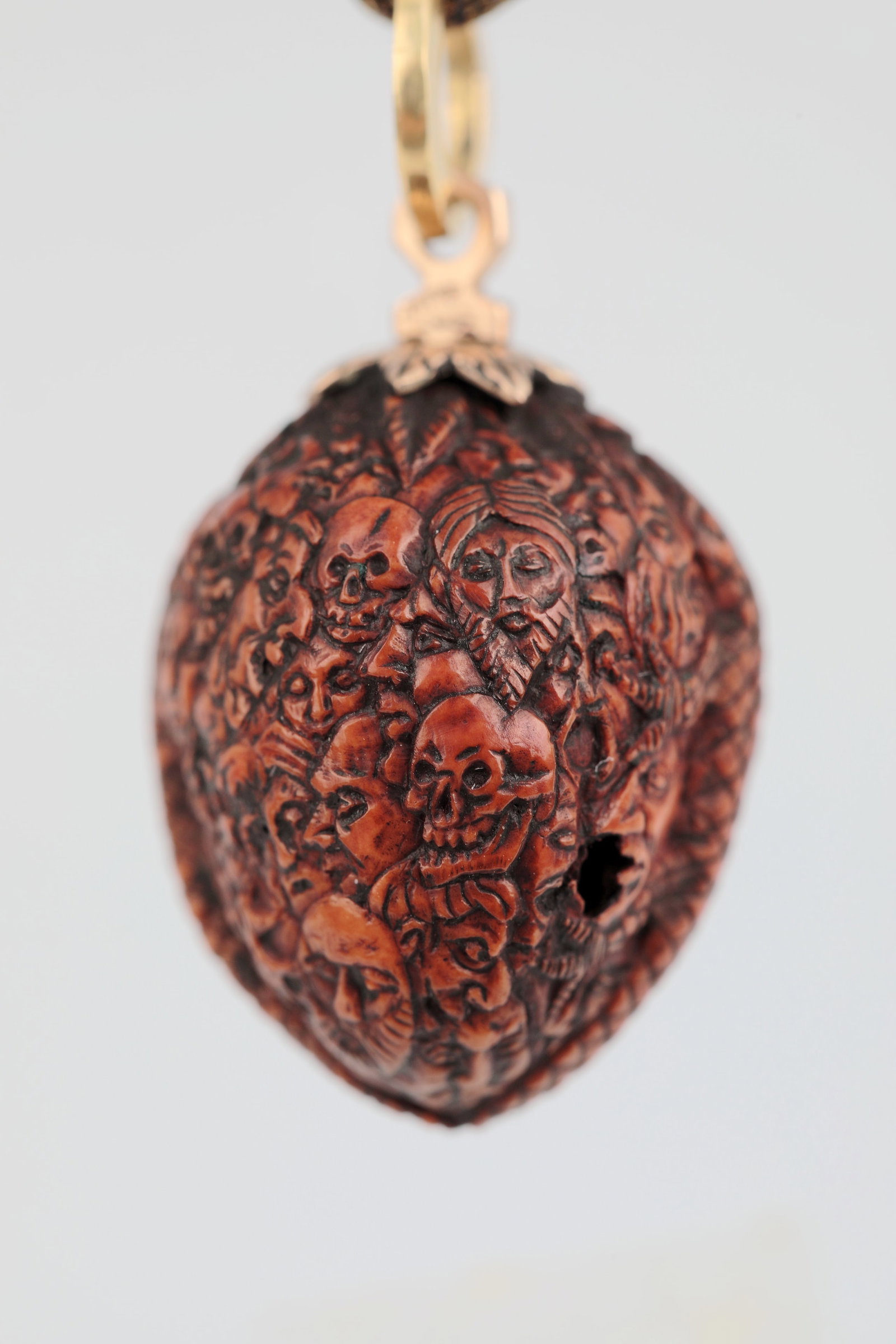Memento mori - Pendant: Memento mori - pendant Alpine, 19th century Hazelnut with over 40 carved faces and skulls, setting and hanging ring made of gold. H. approx. 2 cm, total approx. 3 cm