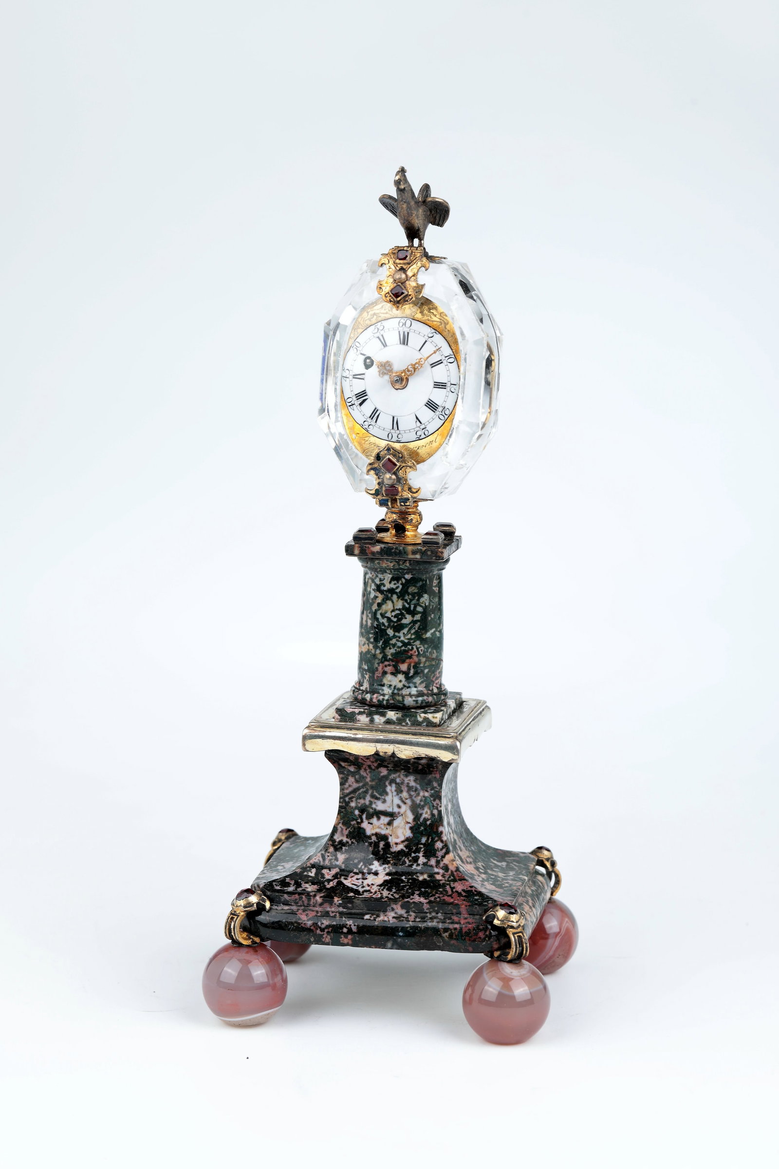 Table clock: Table clock Denmark, Copenhagen, Isaac Larpent, c. 1740 Rhodonite column structure supported by four agate balls, decorated with appliqués of gilded settings with garnet embellishment. Watch case mad