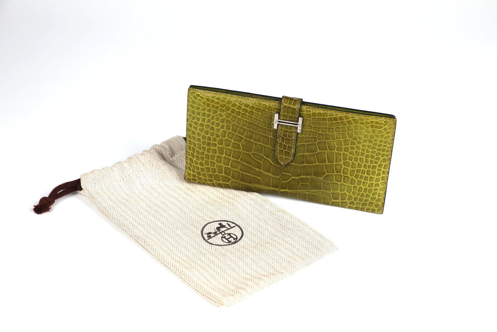 Hermès: Wallet Béarn Bi-Fold: Hermès Béarn Bi-Fold Wallet after 2004 Béarn Bi-Fold wallet in olive green in shiny alligator leather with openwork silver H-buckle. Olive green. Inside, four slit pockets, a coin pocket with