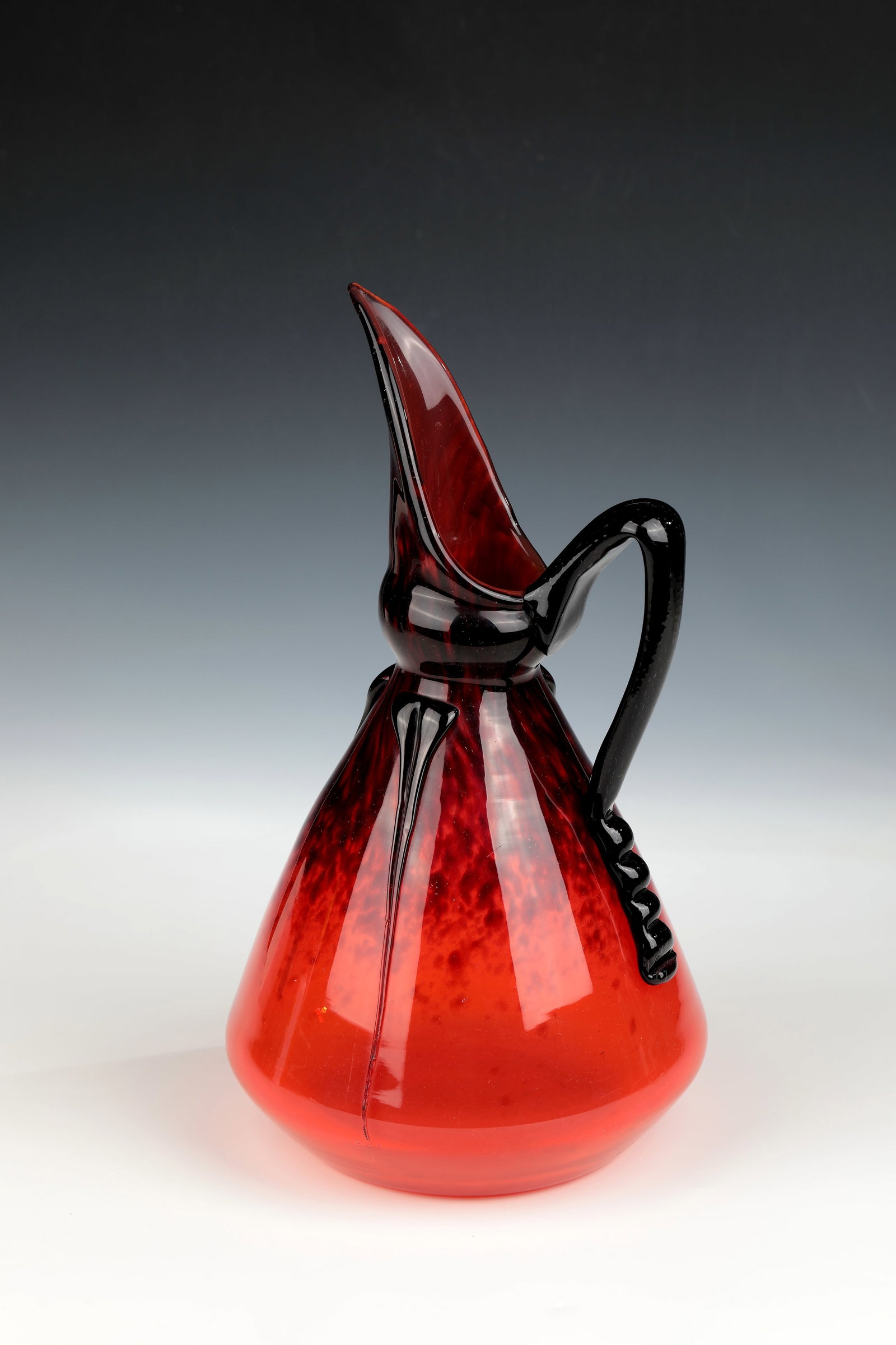 Mug: Jug Verreries Schneider, Epiney-sur-Seine, 1922 - 1924 Colourless glass with melted powder in red and violet, slightly underlaid with brown-violet opal. Pinched handle, jagged, ending in violet