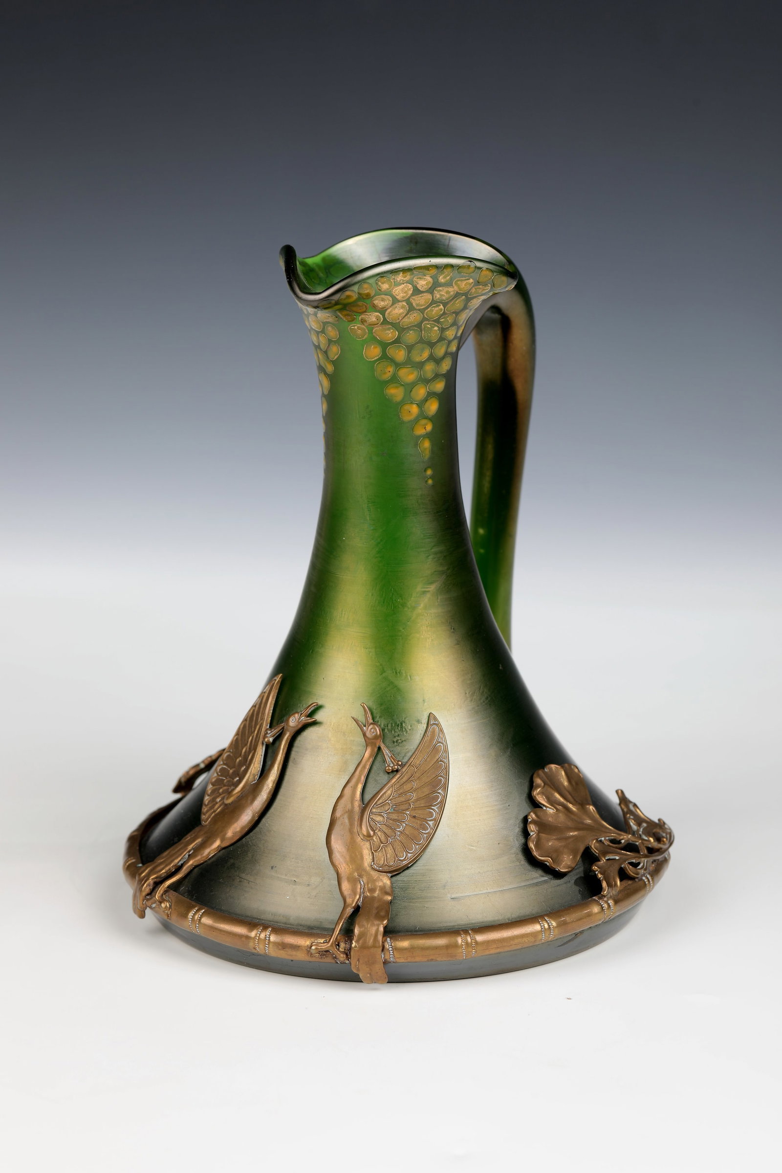 Mug with brass mount: Mug with brass mount Bohemia, c. 1900-1910 Colourless glass, dark green underlay. Model-blown and free-formed, free-attached handle. Below the trefoil muzzle, decorated in several rows, painted in