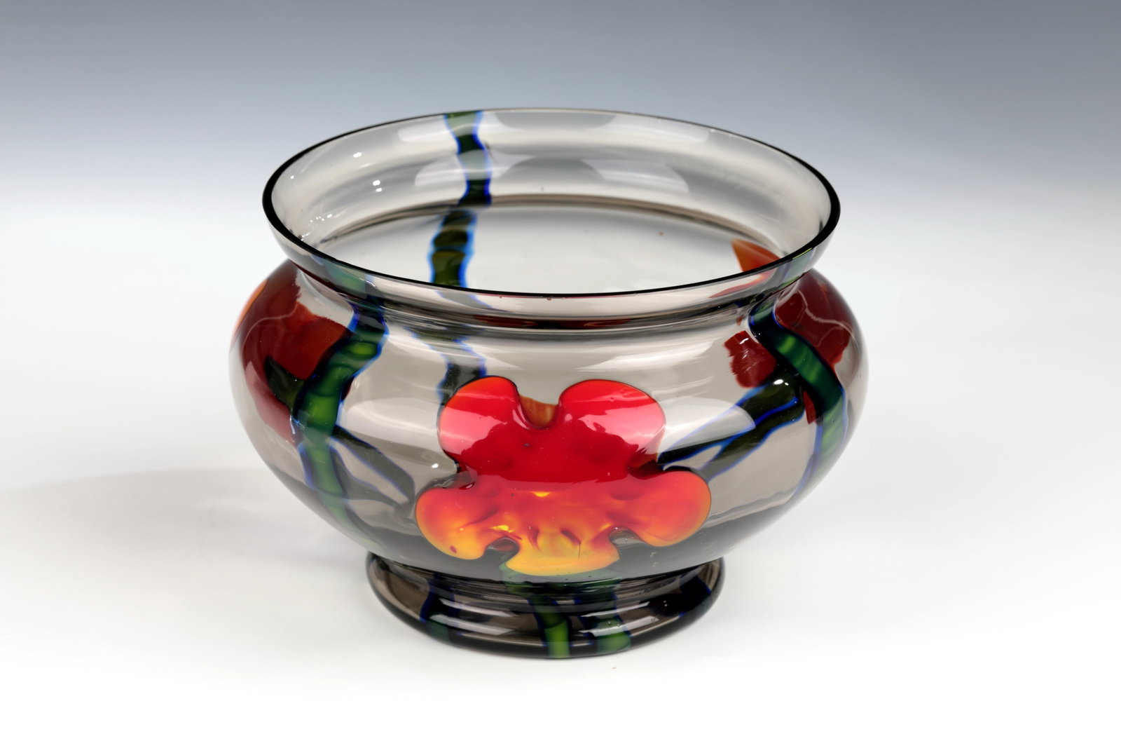 Shell: Bowl Wilhelm Kralik Sohn, Eleonorenhain, c. 1925-1930 Smoky grey glass. Vertical thread- and leaf-shaped ribbon melting with stylised flower overlays in orange-red, green and blue in triple repeat.