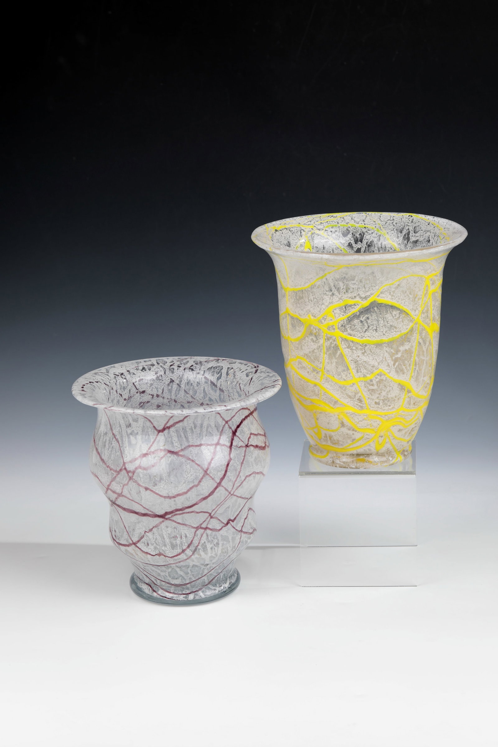 Two vases: Two vases Loetz Wwe., Klostermühle, c. 1935 So-called foam glass. Colorless glass. Melted, white powder and melted threads in yellow or violet. H. 18.8 - 20.8 cm.