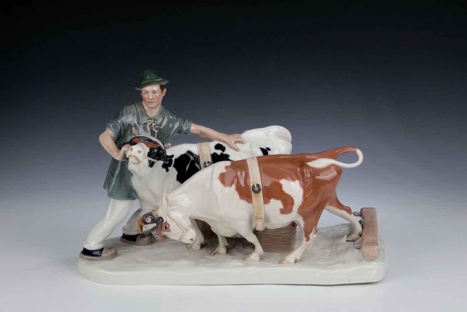 Farmer with cow team: Farmer with cow team Meissen, 1924 - 1934, Otto Pilz (design) Farmer standing on a natural pedestal, holding a cow team with a harrow and two fallen baskets. Polychrome underglaze painting. A horn