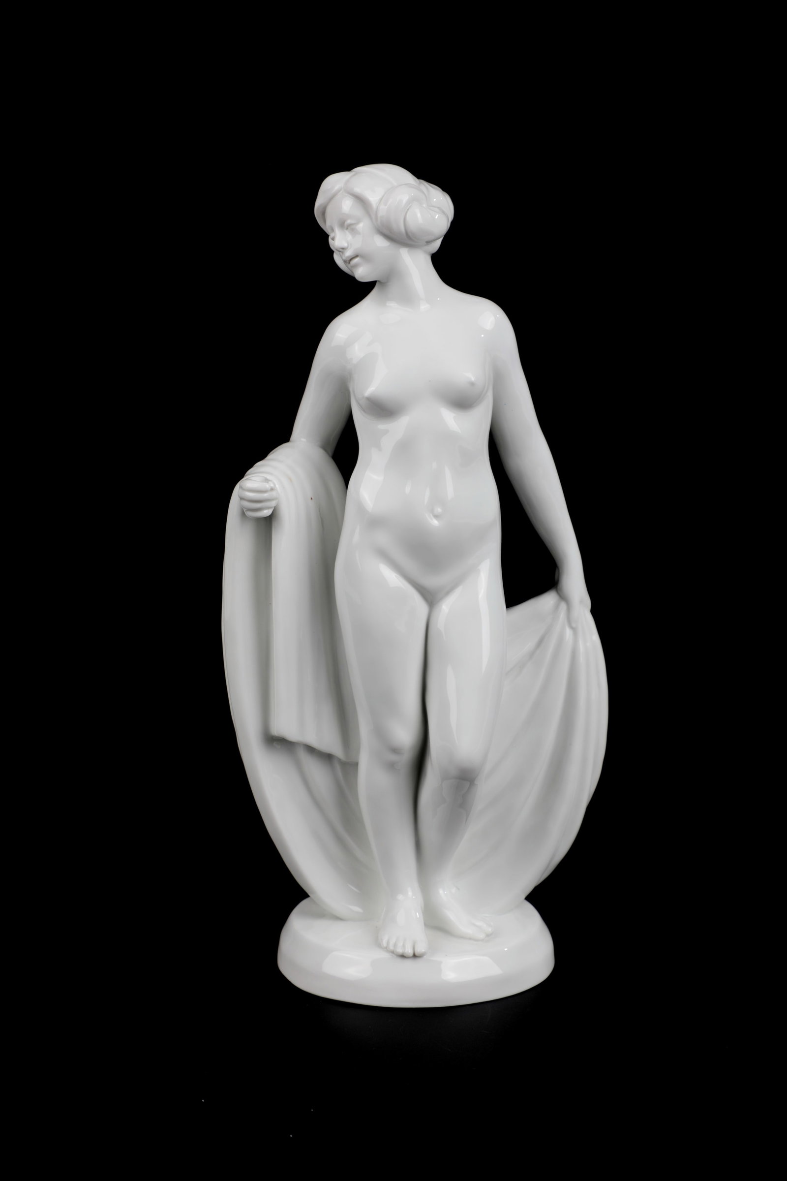 ''After the bath'': ''After the bath'' design Theodor Eichler, Meissen 2nd half of the 20th century Female nude with cloth standing on a round pedestal. White porcelain, glazed. Model No. 73565. Sword mark. H. 23cm.