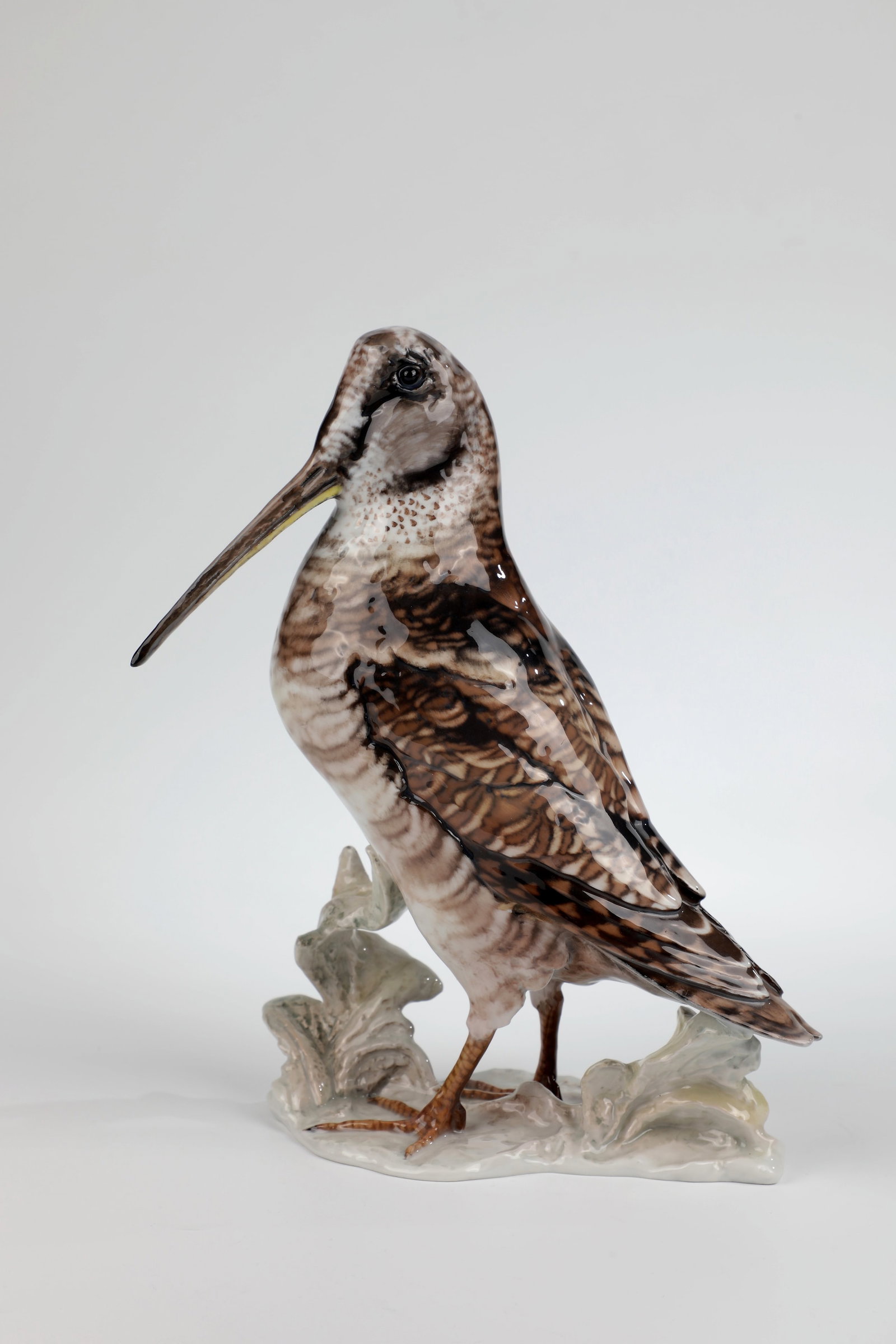 Snipe: Snipe designed by Fritz Heidenreich 1942/43, Rosenthal 1948 Snipe standing on a natural pedestal in naturalistic underglaze painting in shades of brown. Green stamp in the ground. On the pedestal sign