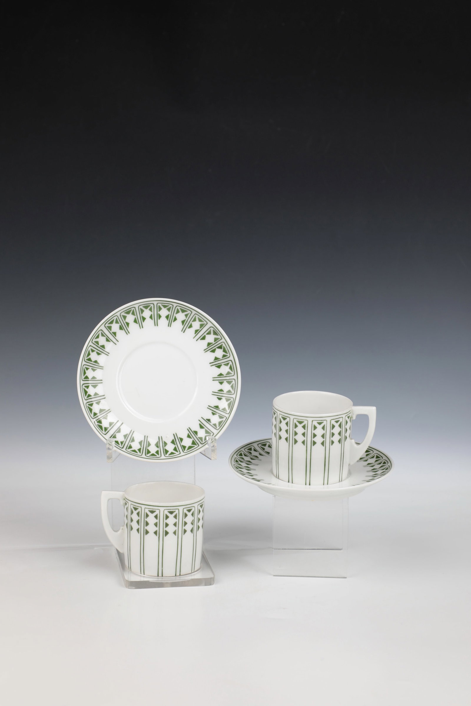 Pair of mocha cups: Pair of mocha cups Designed by Therese Trethan, Ernst Wahliss, Vienna around 1903 Cylindrical shape with geometric overglaze decoration in green with rectangular and triangular patterning. Underside
