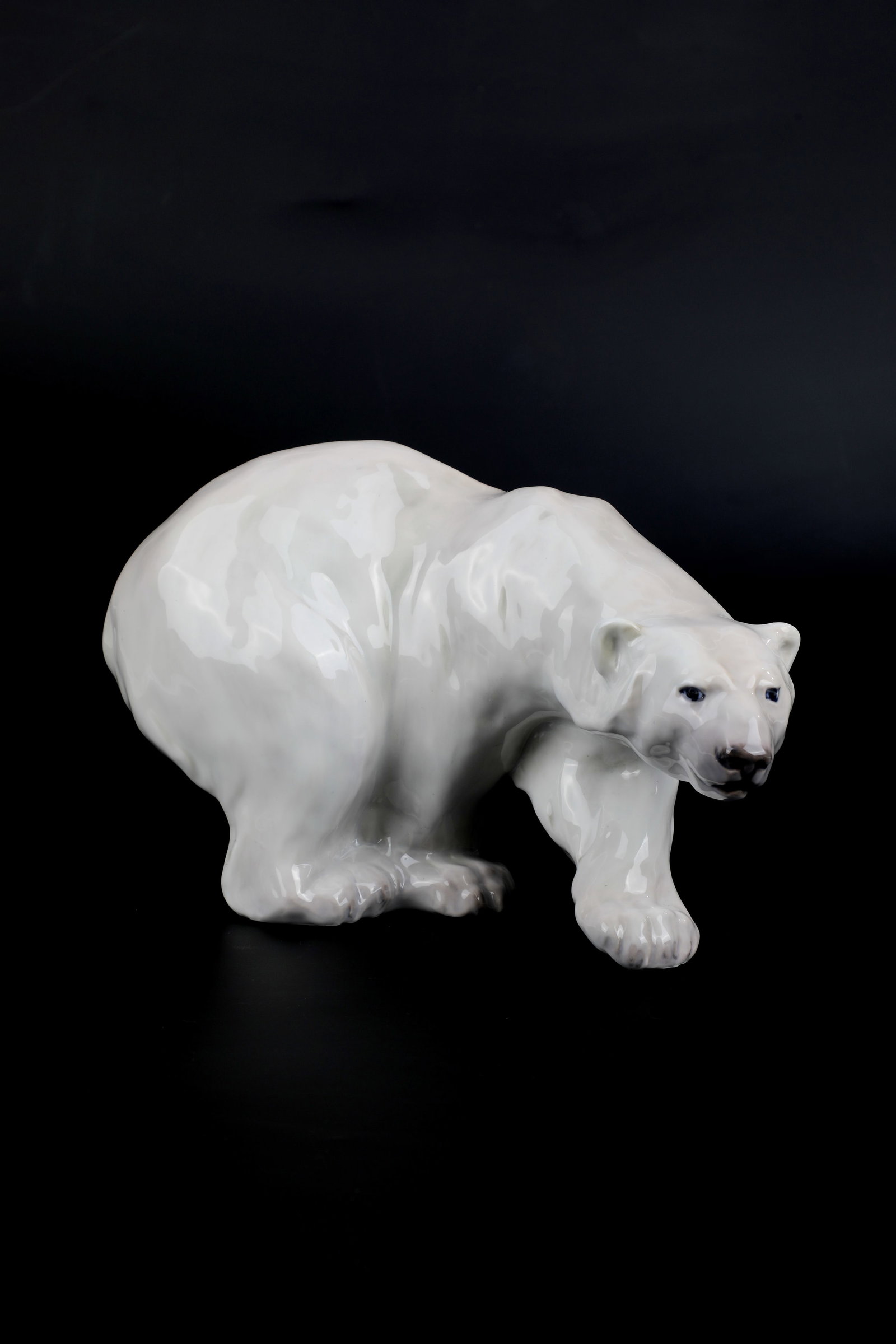 ''Striding Polar Bear'': ''Striding Polar Bear'' designed by Knud Kyhn, Royal Copenhagen around 1930 In sparse, naturalistic underglaze painting. On the bottom manufactory brand and model no. 1137. H. 16.5 cm, L. 27.5 cm.