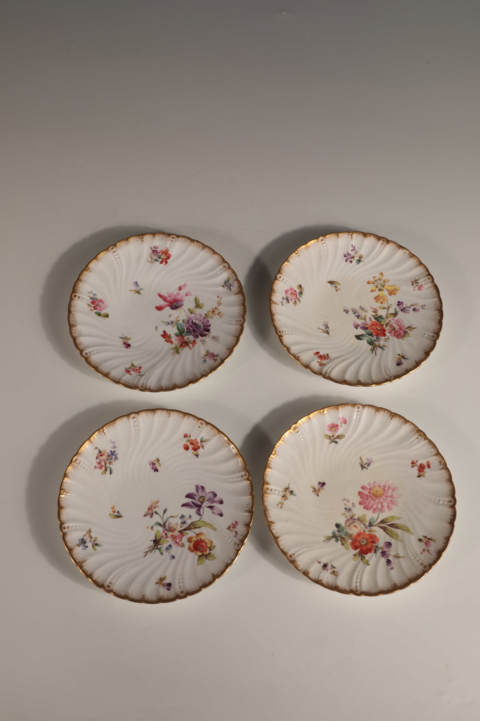 Four plates: Four plates 20th century porcelain. The mirror and the gastroone flag with polychrome floral decoration. Combed gold rim. All plates with unknown, underglaze green manufactory mark (?) and various