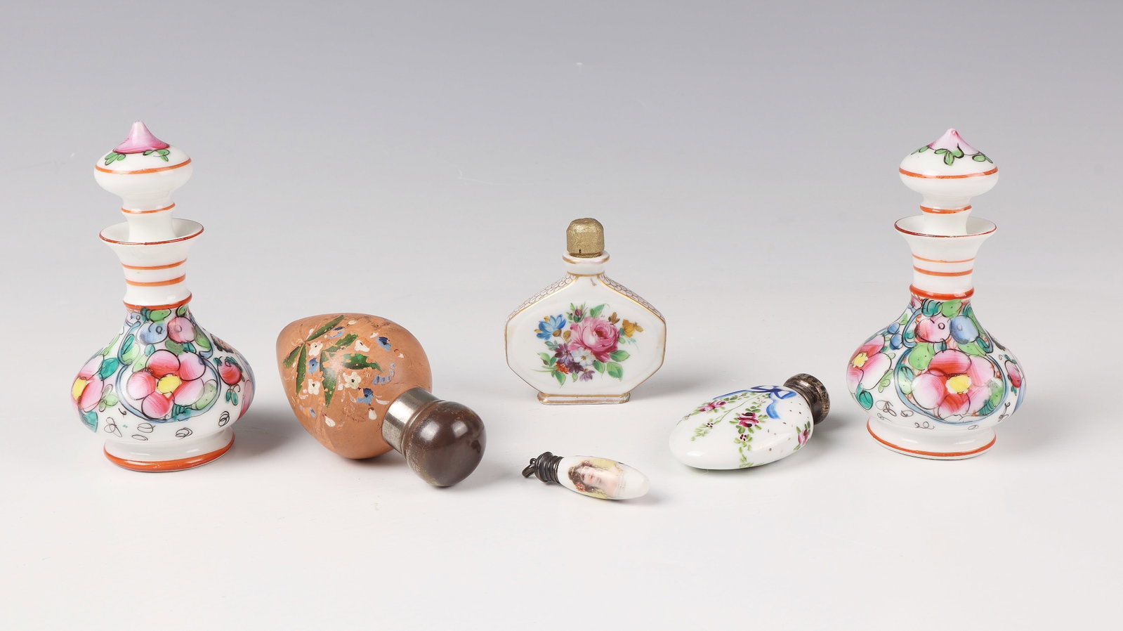 Mixed Lot of Six Miniature Bottles with Stoppers: Mixed lot of six miniature flacons with stoppers, 20th century, porcelain and clay with polychrome flower painting, a portrait of a lady. H. 3 - 9 cm.