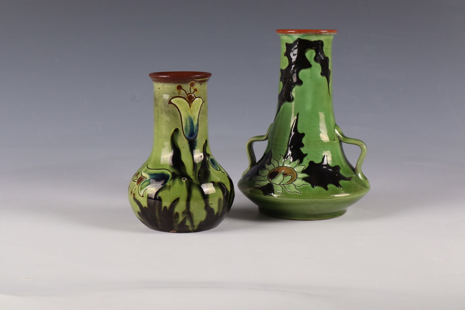 Two vases: Two vases Paul and Anna Wranitzky, Frainersdorf, around 1900 Red-brown shards, glazed green and decorated in polychrome slip painting with flower stylizations. A vase in the bottom with the press mark