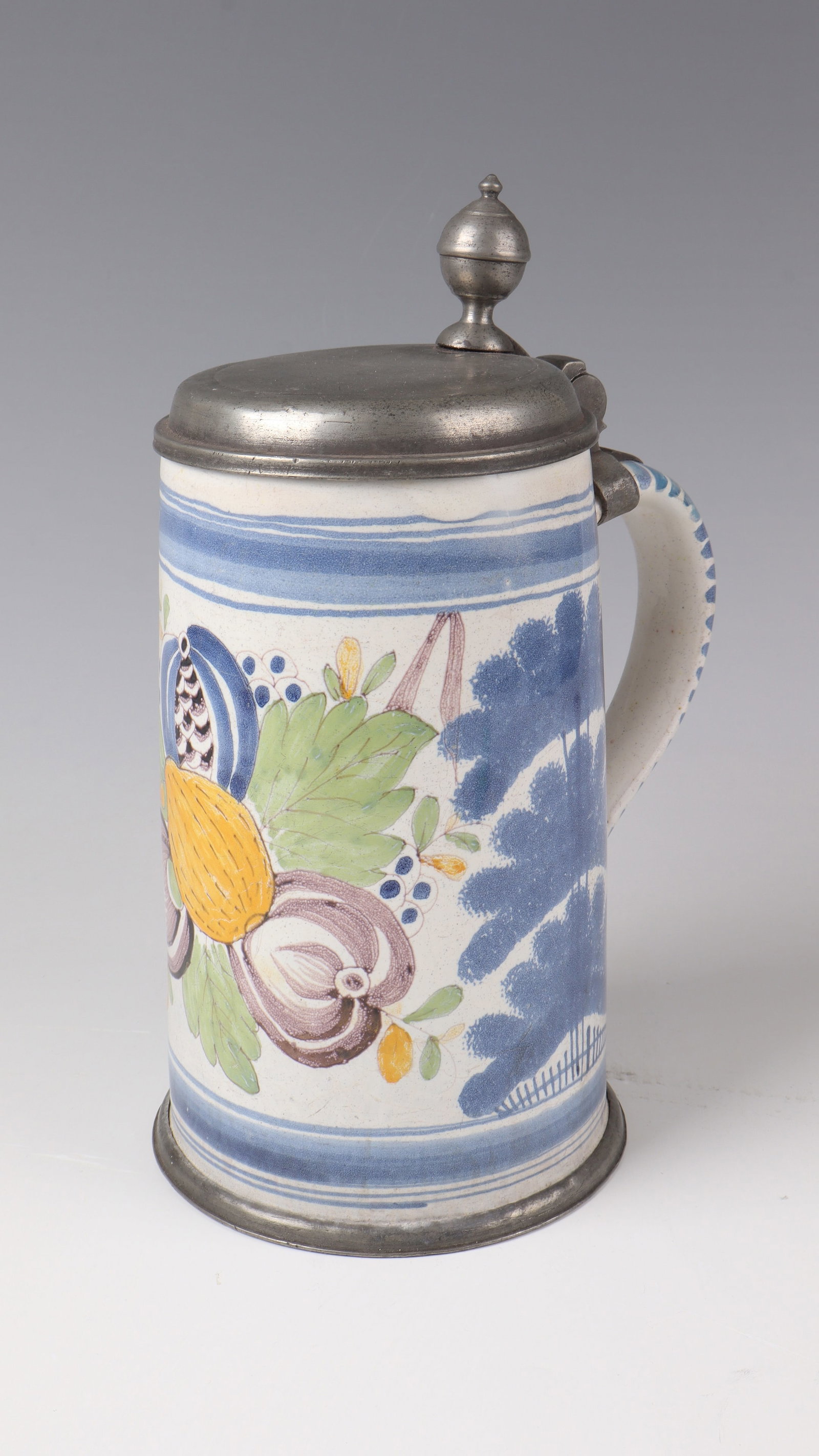 Roller jug with tin lid: Roller jug with tin lid Bayreuth, M. 18th century Fruit arrangement painted on a white-glazed background in bright sharp-fire colours with foliage between blue, sponged floor trees. Ribbon handle