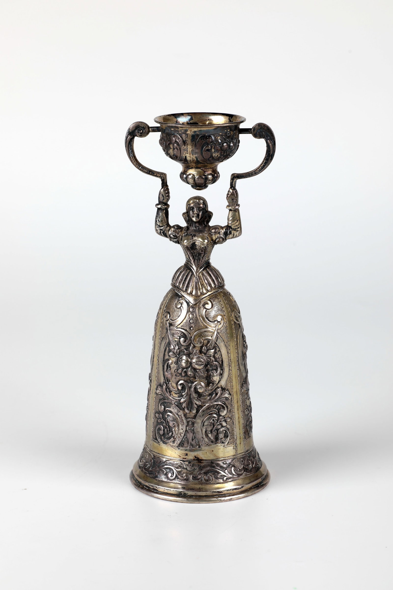Bridal Mug: Bridal cup 19th century silver, gilded. Skirt with embossed fruits and flowers framed by leaf tendrils on a hallmarked background. Small cup also decorated with embossed tendrils. G. 260g. H. 20.5 cm.