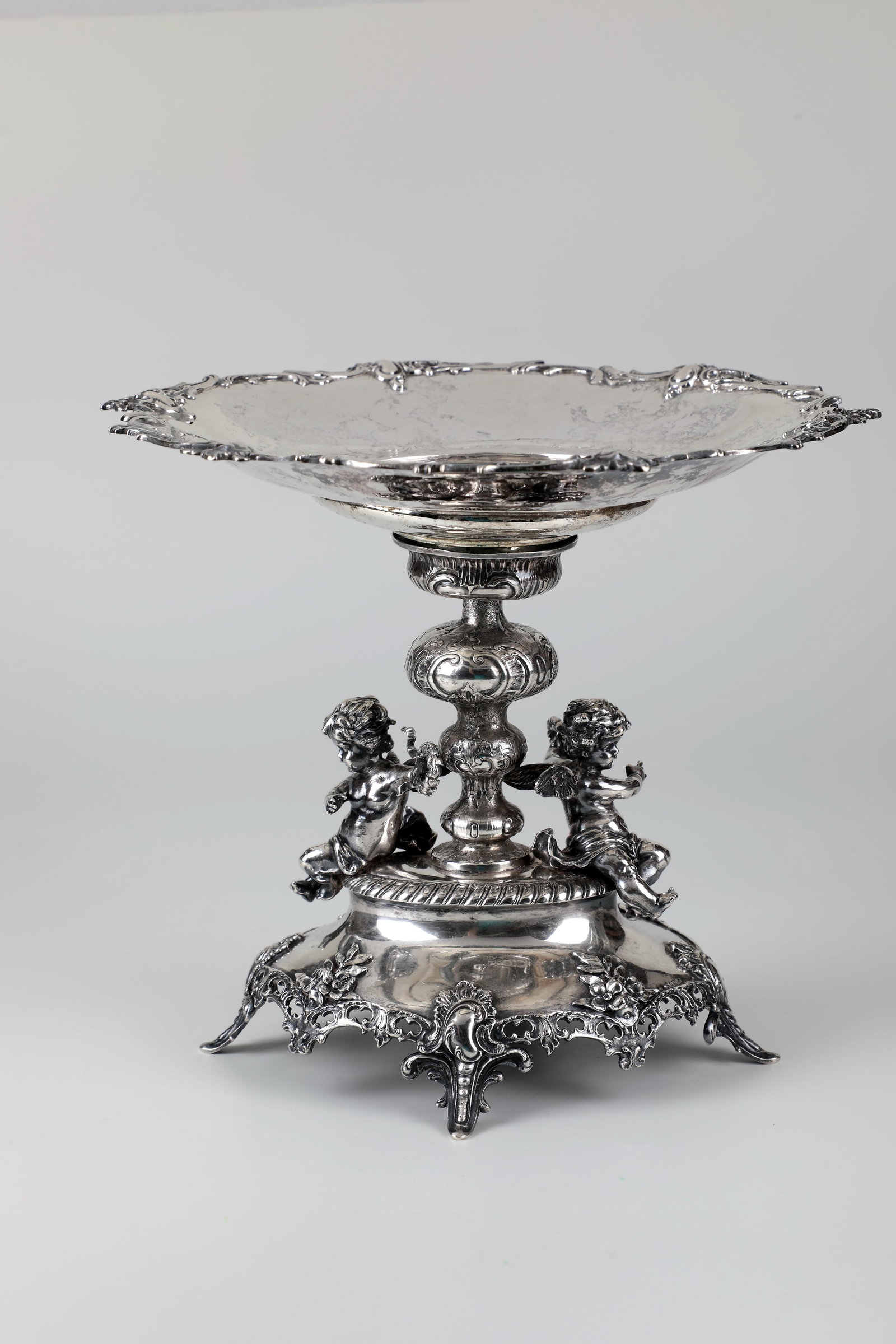 Magnificent centrepiece bowl with cherubs: Magnificent centrepiece bowl with putti German, end of the 19th century, silver. Round, deeply hollowed bowl with finely engraved decoration and richly curved, openwork rocaille rim. On a baluster-sha