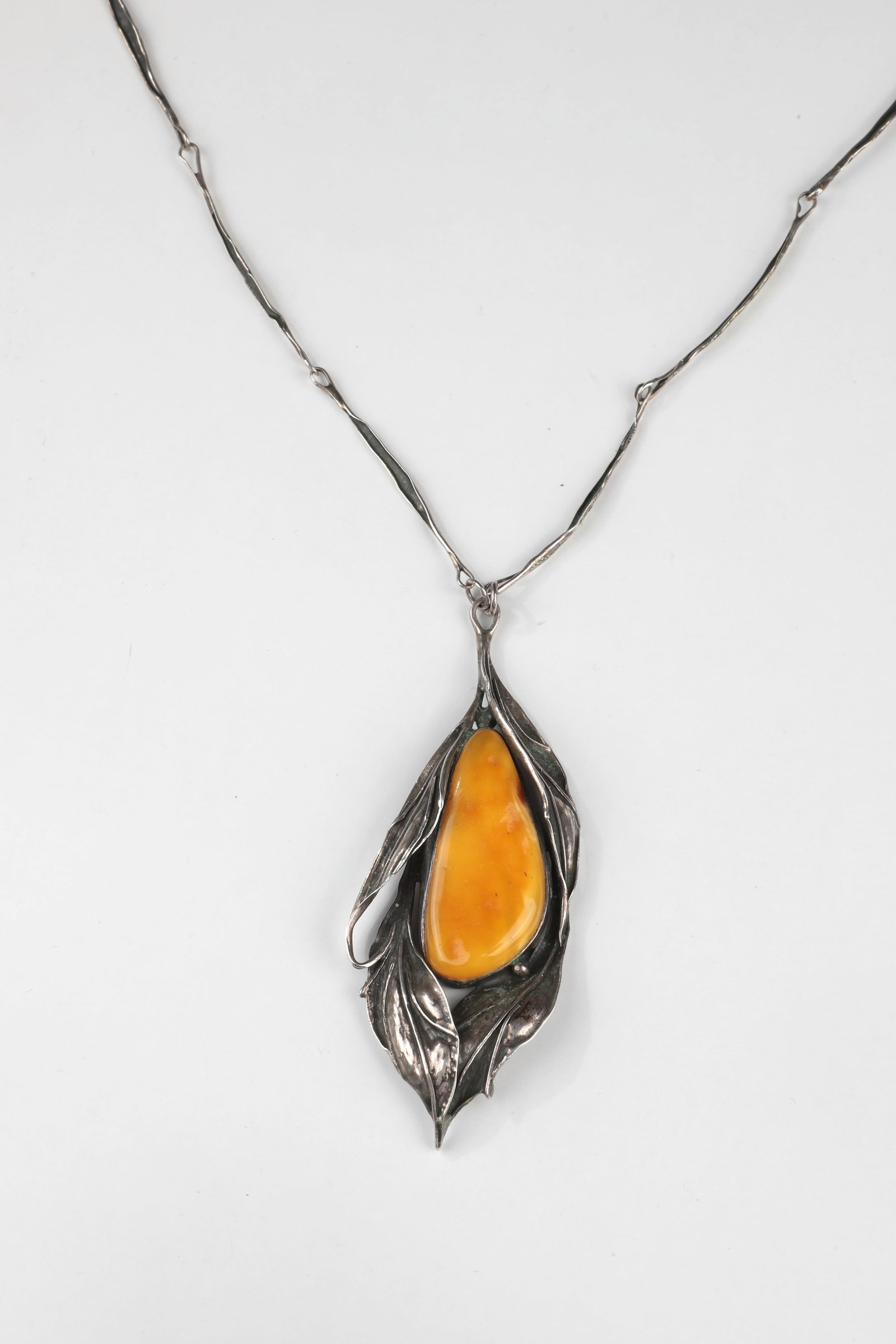 Rare Art Nouveau Butterscotch Amber Necklace: Rare Art Nouveau necklace with Butterscotch amber Bar link necklace with elongated leaf pendant, set with elongated Butterscotch amber, silver (acid tested). L. Pendant incl. eyelet 10 cm; L. Chain